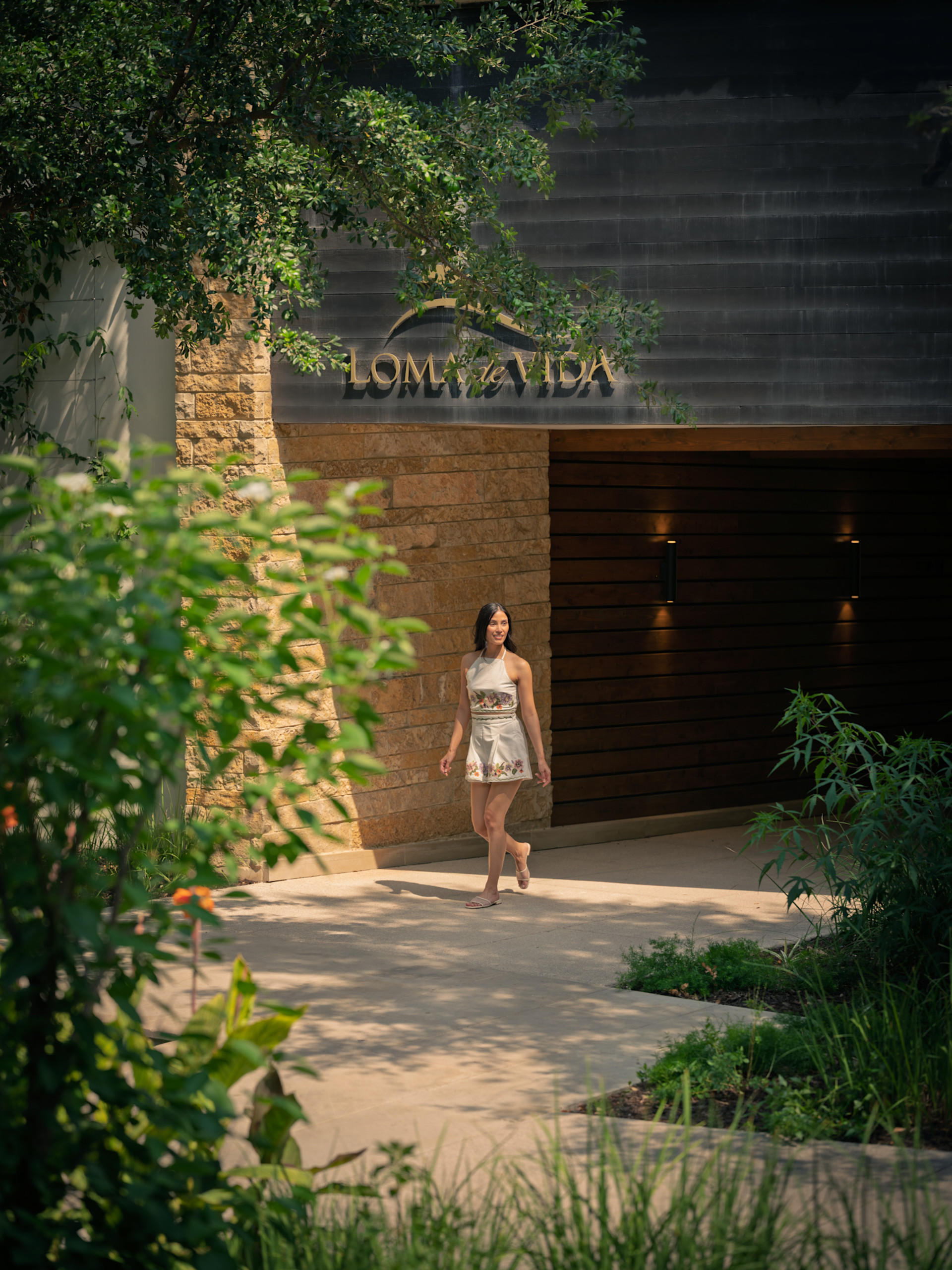 女子在树木掩映的物业外部行走