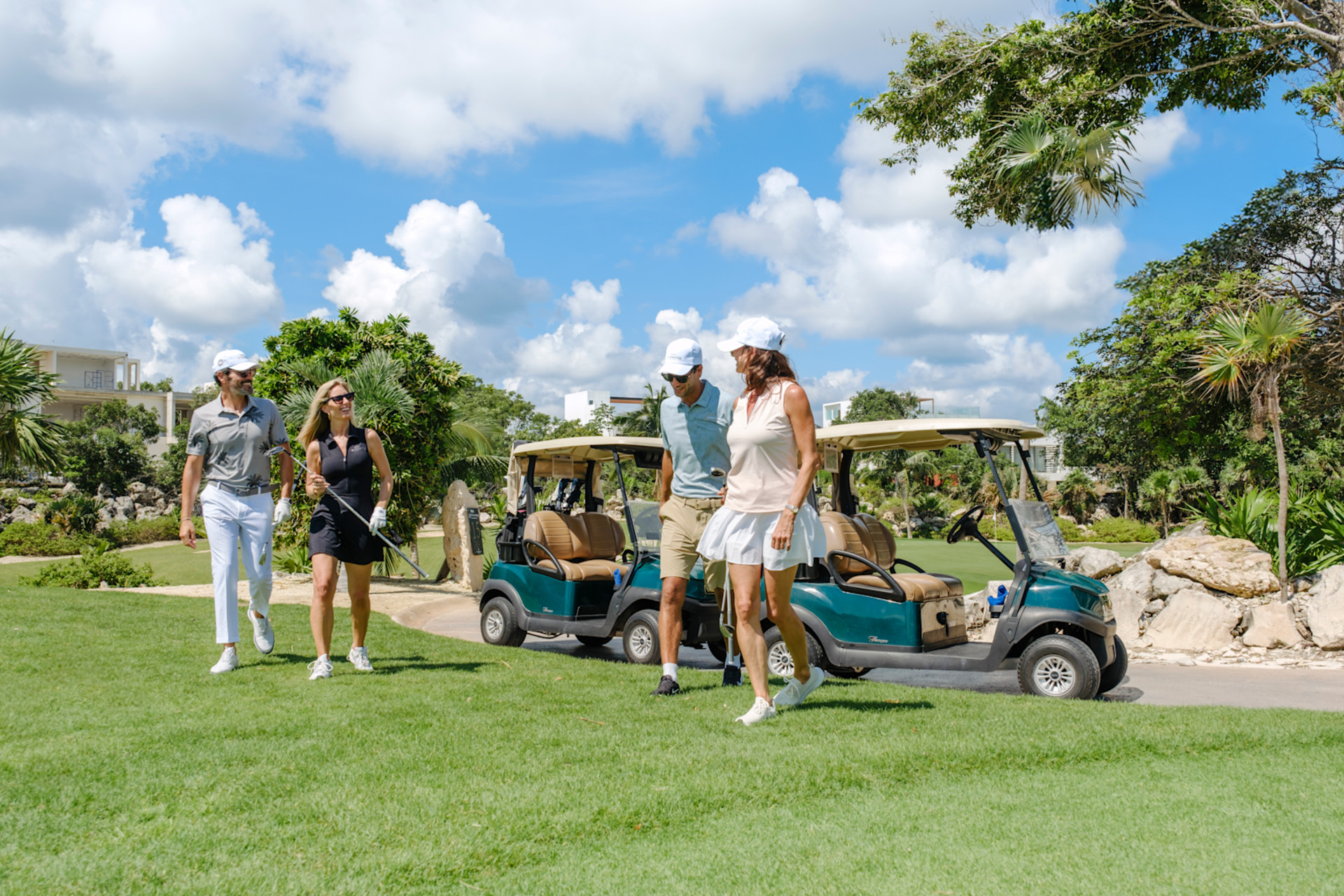 Couple of guests enjoying golf after getting out of golf buggy
