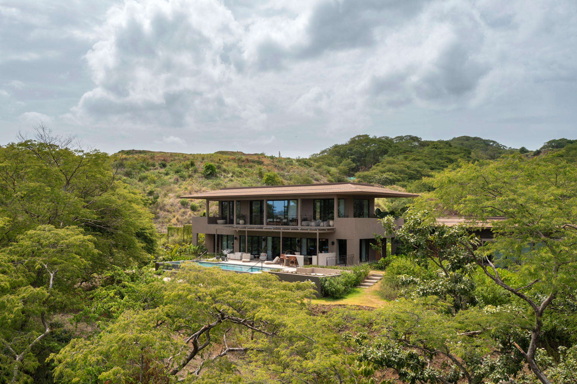 outside view of the presidential suite with private outdoor pool surrounded by trees and hills