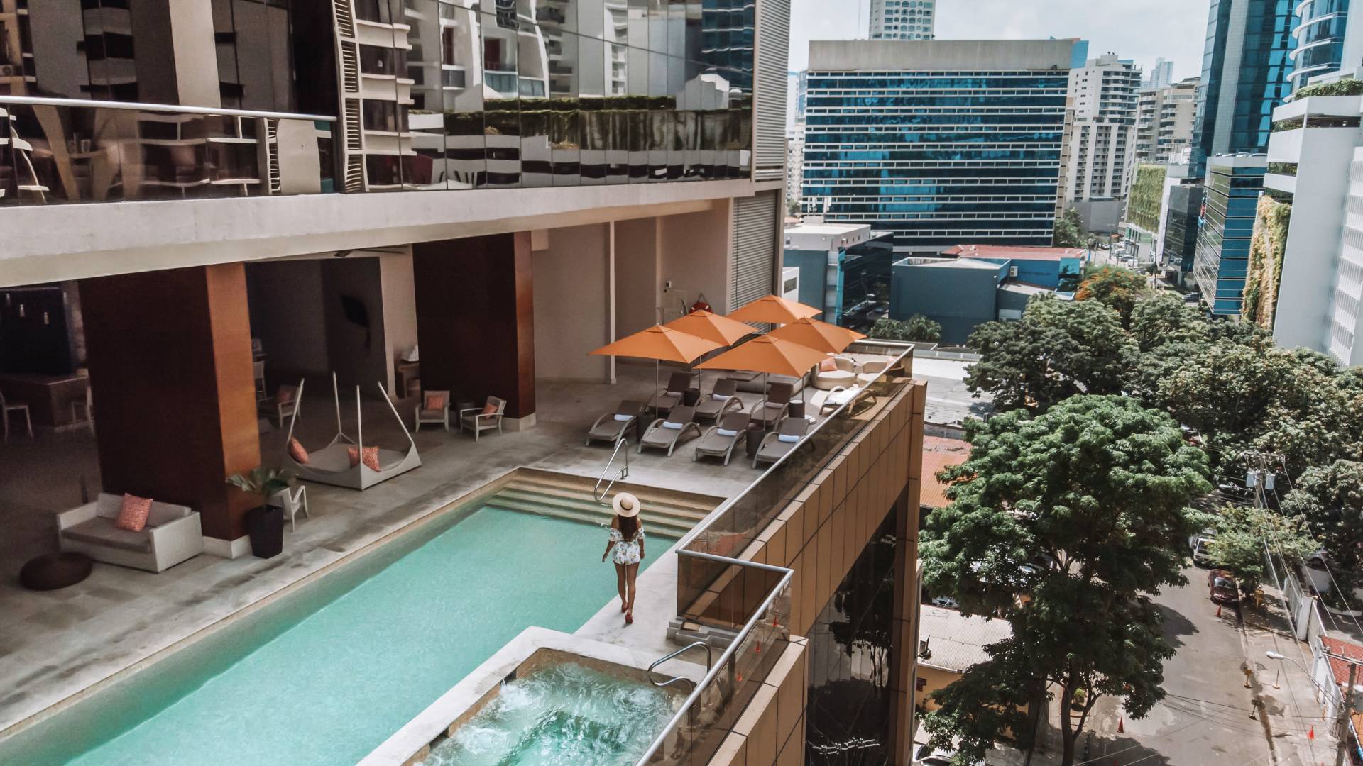Women hanging out by the pool overlooking the city view