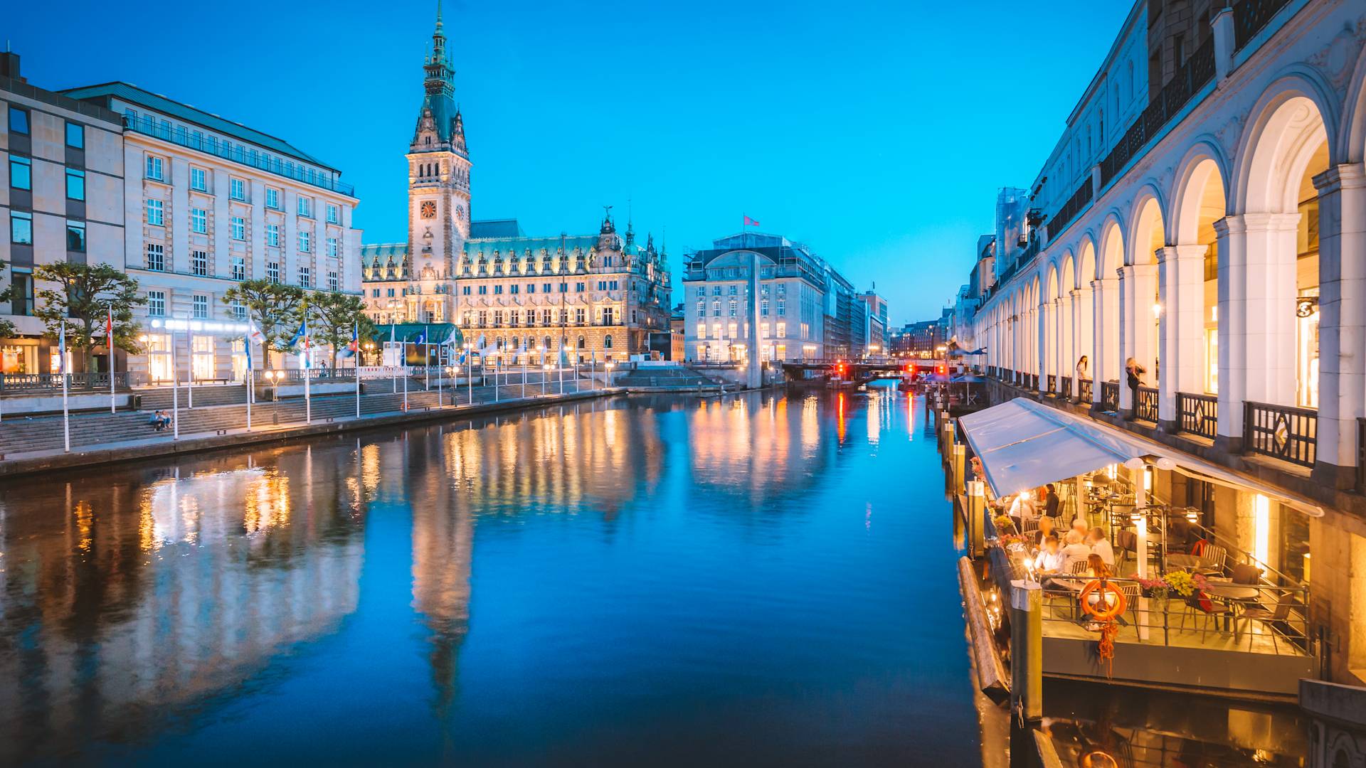 Noční exteriér řeky s restauracemi na břehu řeky