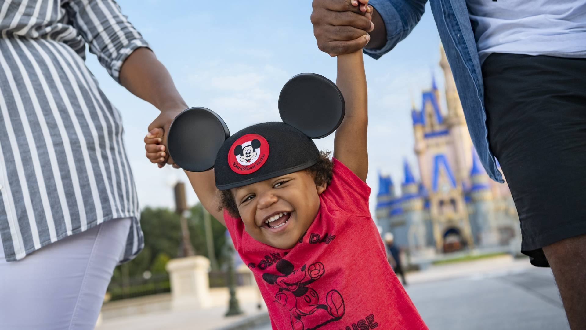 Child with Mickey Mouse ears near Enchanted Castle