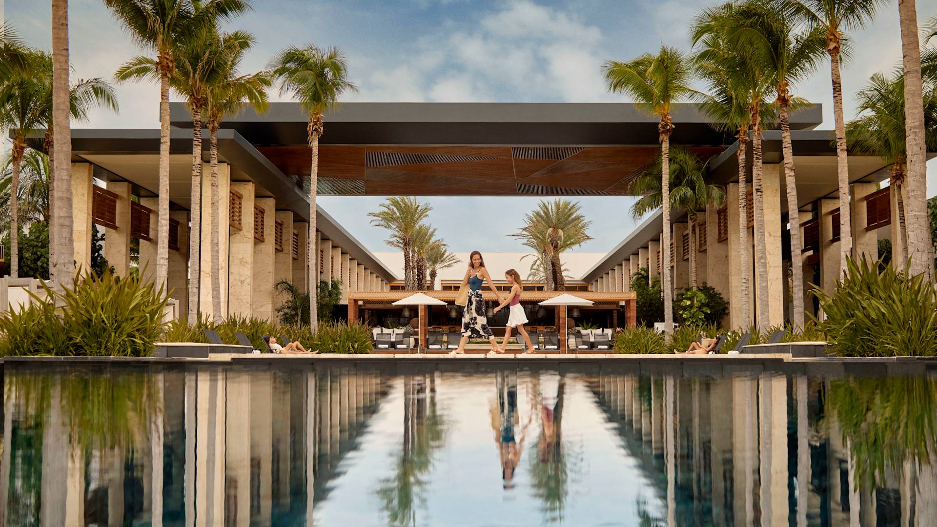 Mum and daughter walking past outdoor pool