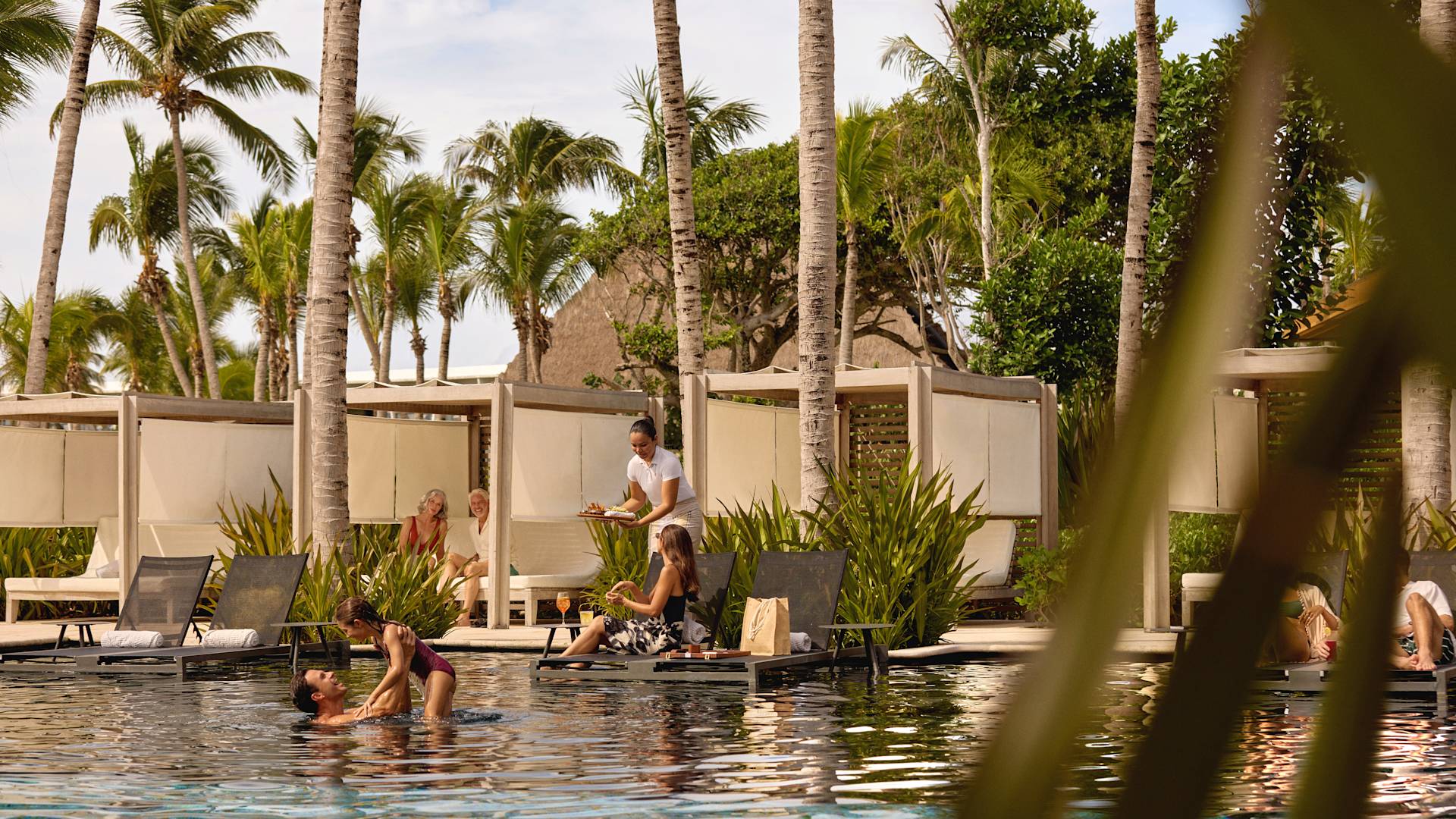 hotel guests enjoying outdoor pool and loungers