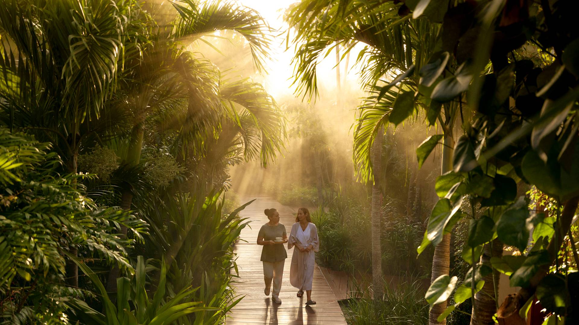 Zwei Frauen gehen durch den Gartenbereich