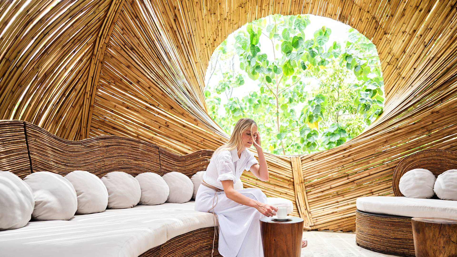 Woman relaxing in comfortable seating area. She is picking up a drink