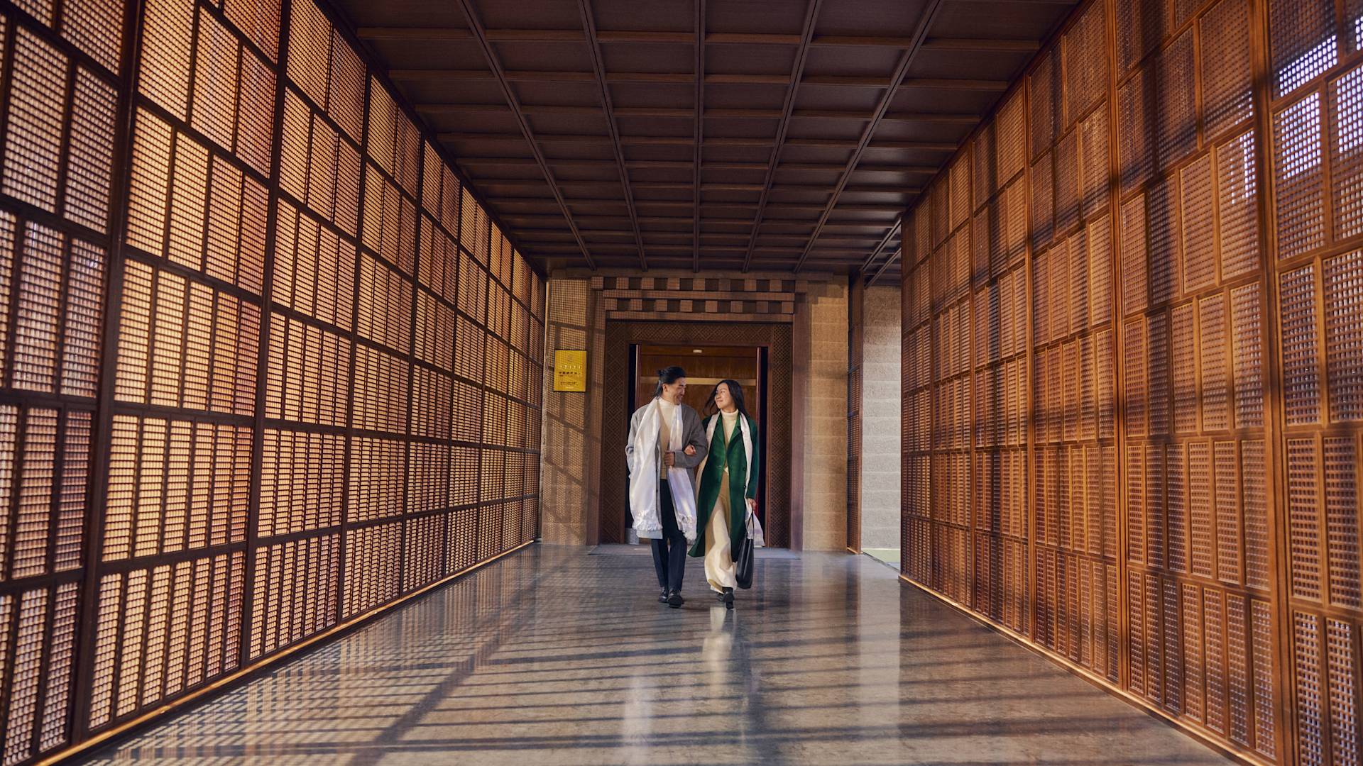 Mężczyzna i kobieta idący korytarzem w holu