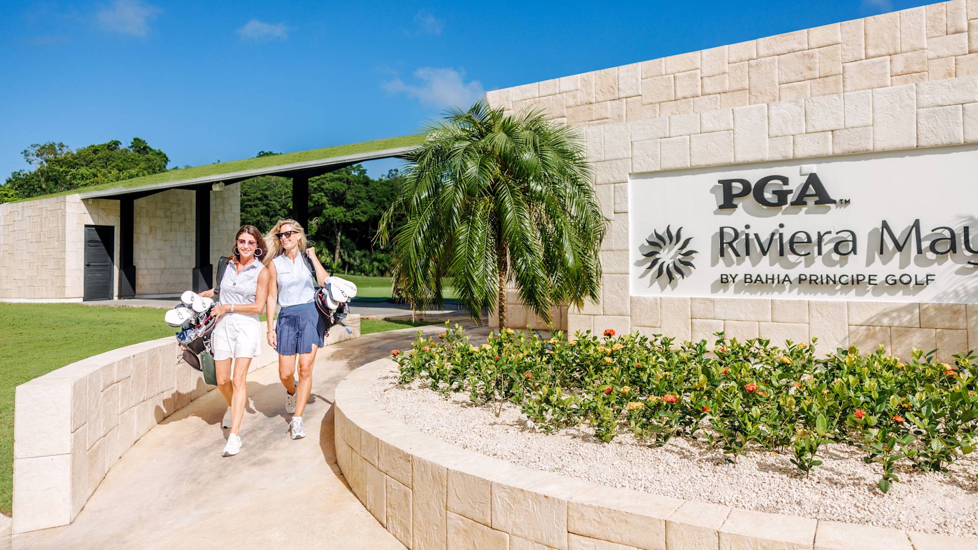 Two Women Walking at the Entrance of PGA Riviera Maya by Bahia Principe Golf