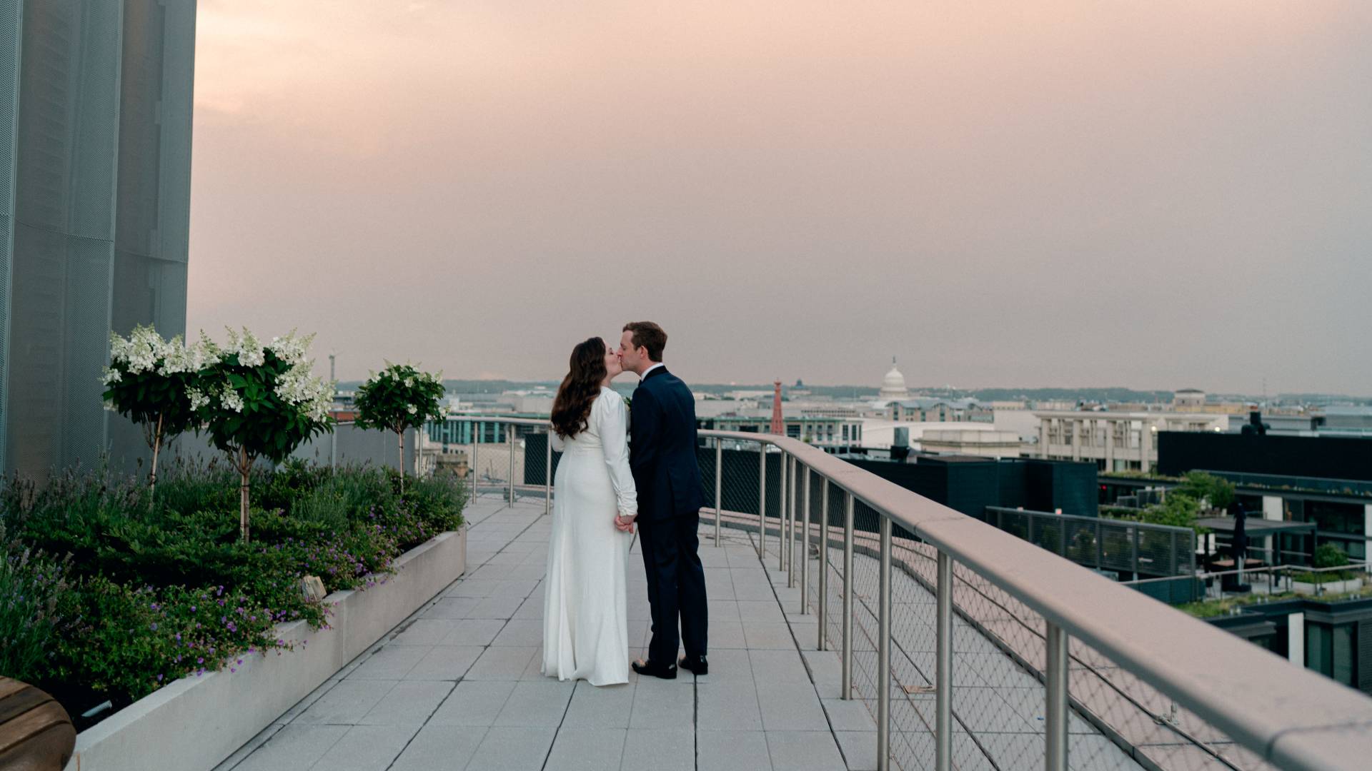 couple kissing outdoors on their wedding day at sunset