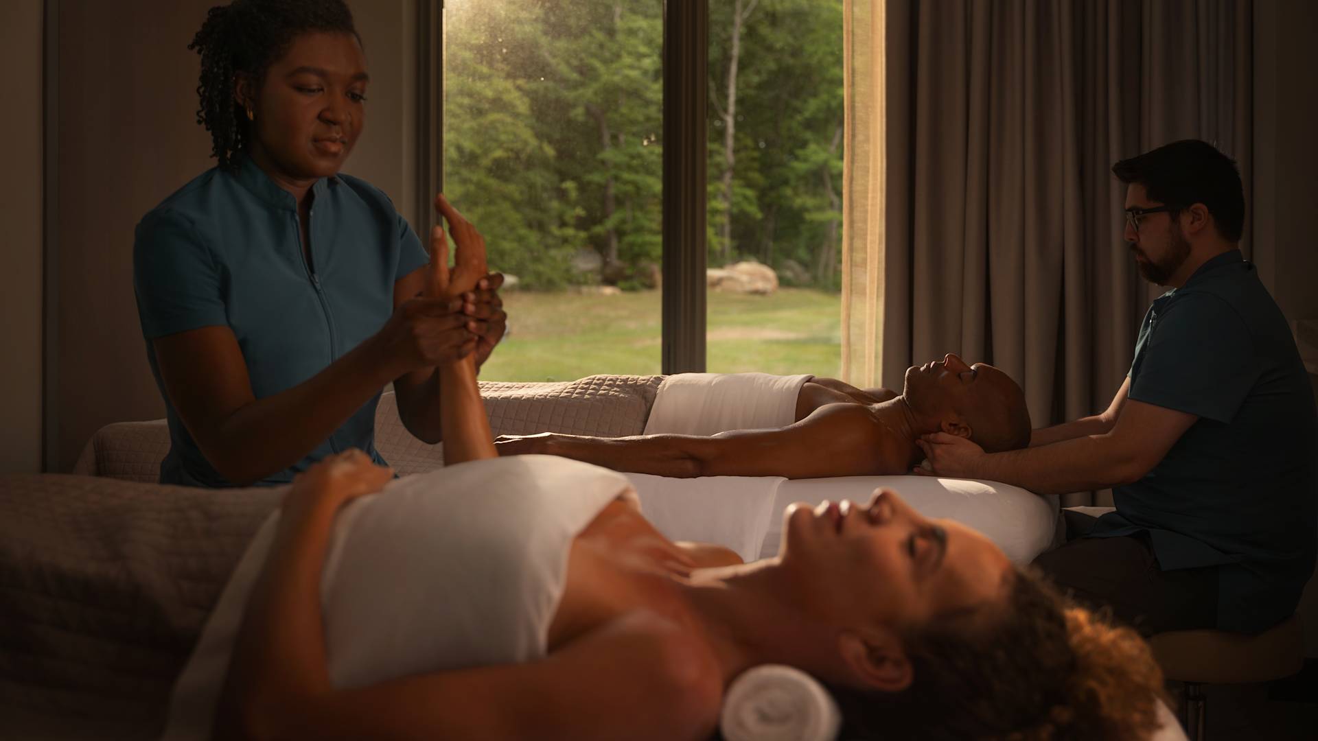 Düşük ışıklı odada masaj yapan çift.