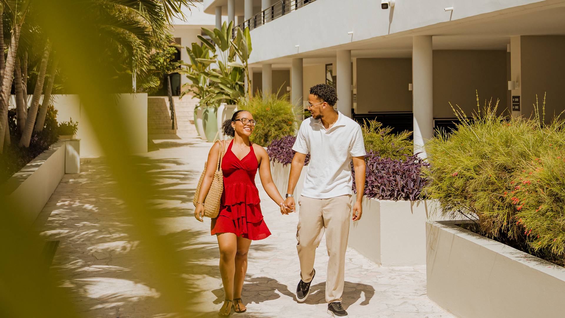 Couple Holding Hands is Walking on Hotel Grounds