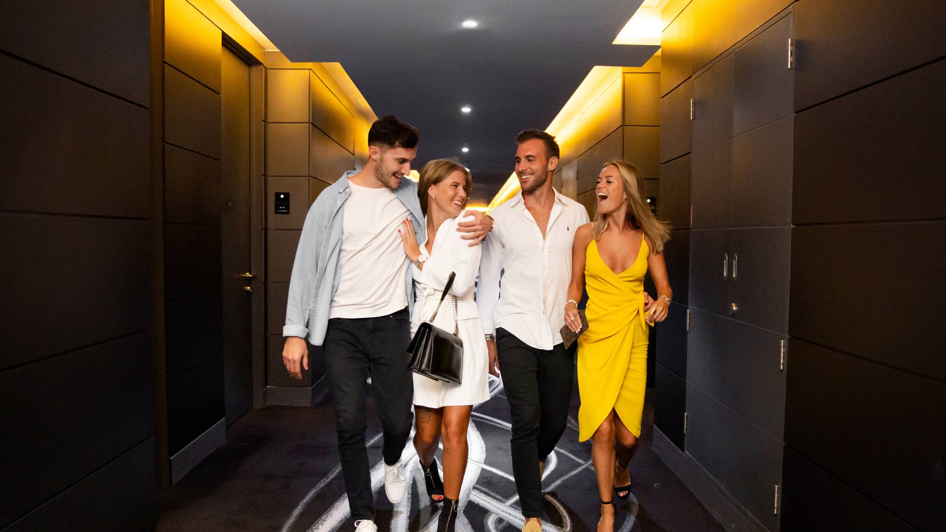 Two Couples Walking on Hotel Hallway