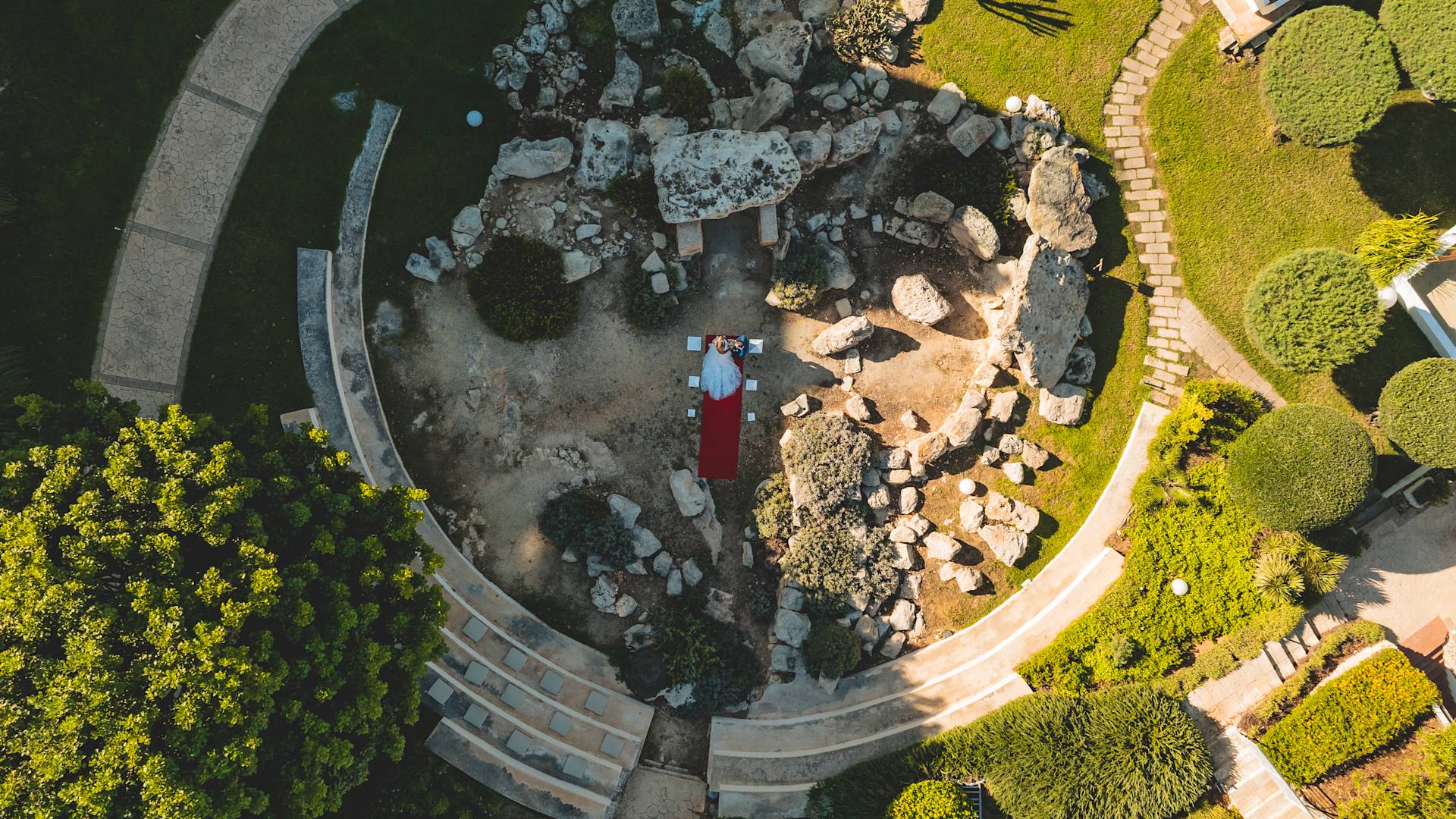 Un cuplu de nunți stă împreună în curte într-o zi însorită