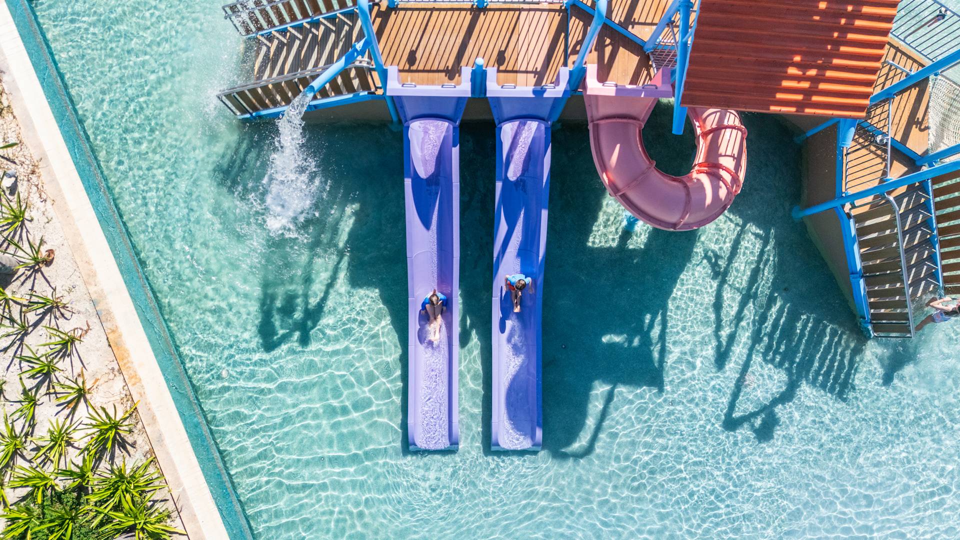 Kids on Slides in an Outdoor Swimming Pool