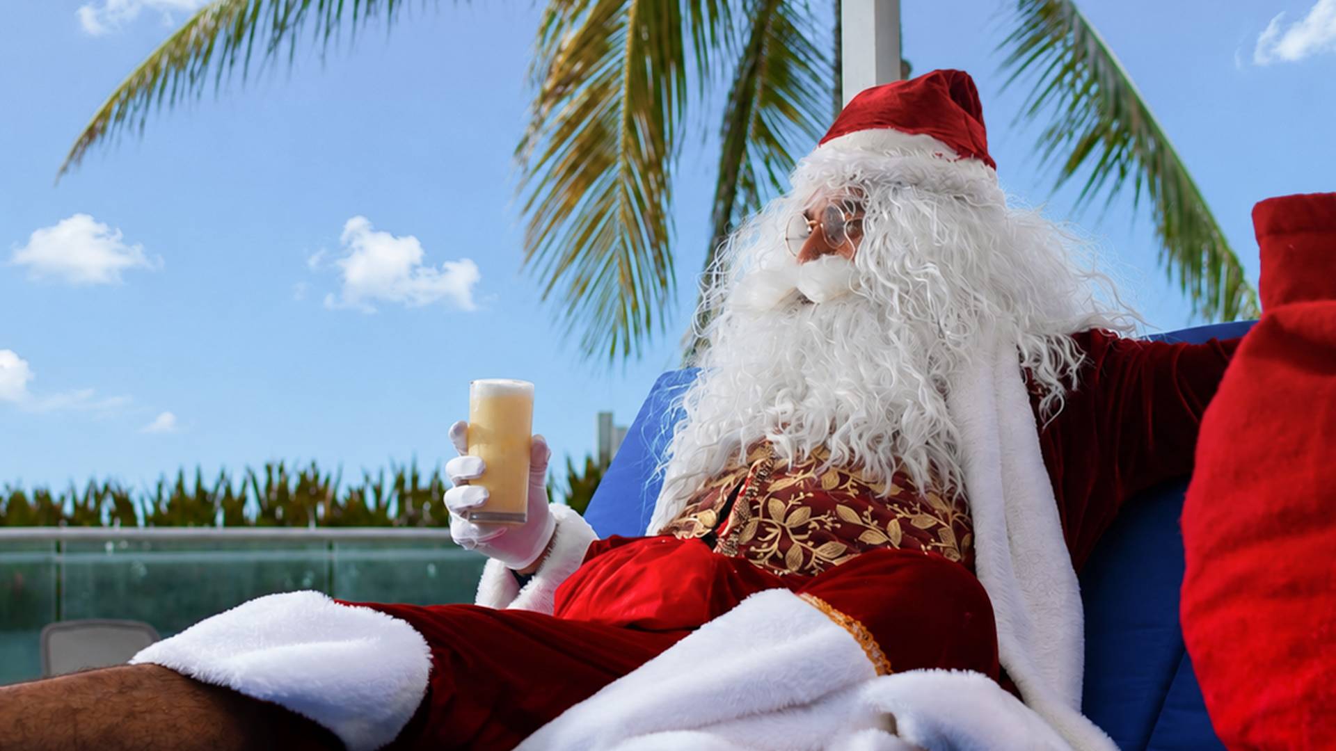 Santa Claus is Enjoying Juice While Lying on a Covered Lounge Chair Outdoors