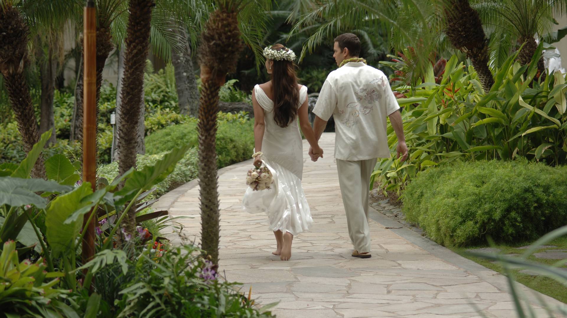 Couple marchant dans un jardin tenant les mains