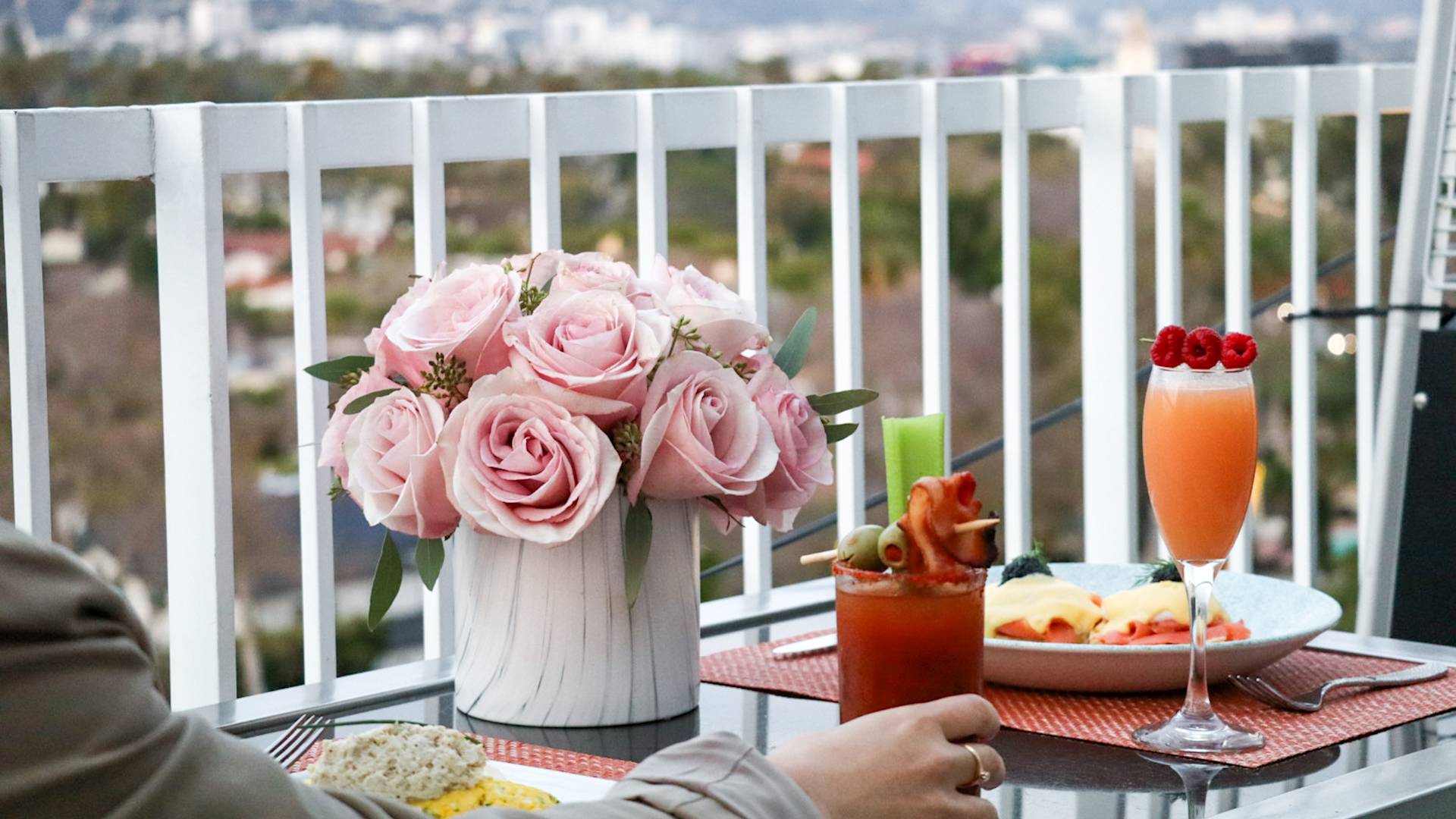 Breakfast food and cocktails at an outside table.