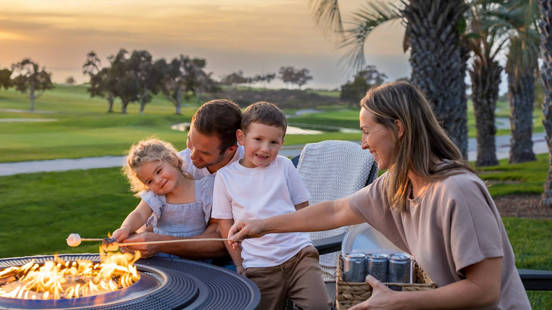 a family enjoying smores at sunset on the courtyard  firepit