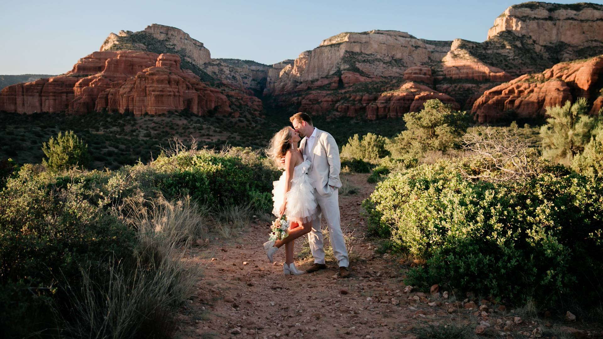 bride and groom kissing, mountains in the background