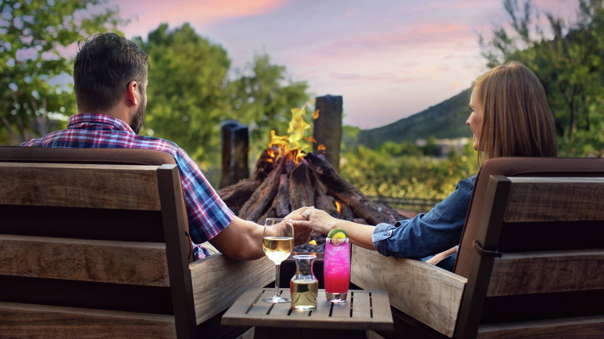 Couple Having Cocktails Seating by Firepit at Sunset
