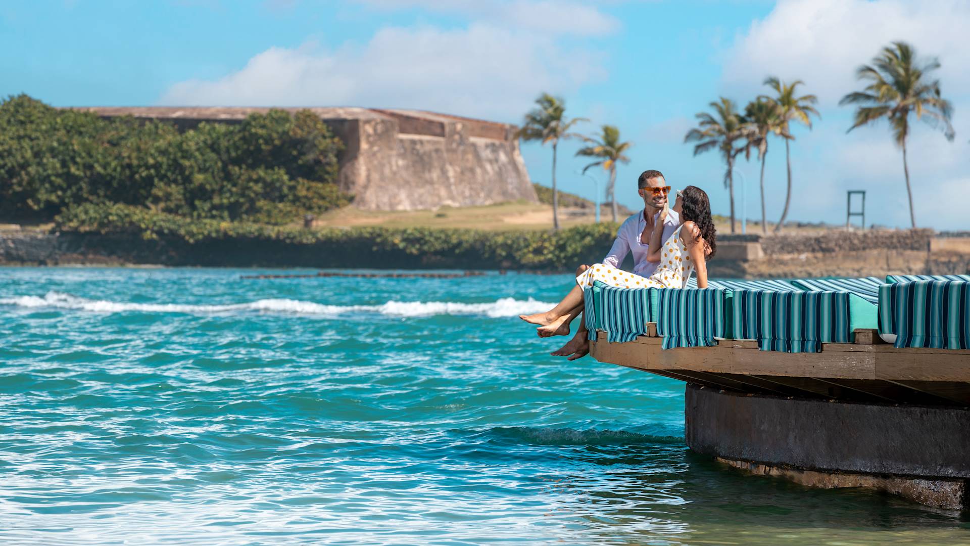 Couple Sitting on a Platform, and Talking while Enjoying the Water