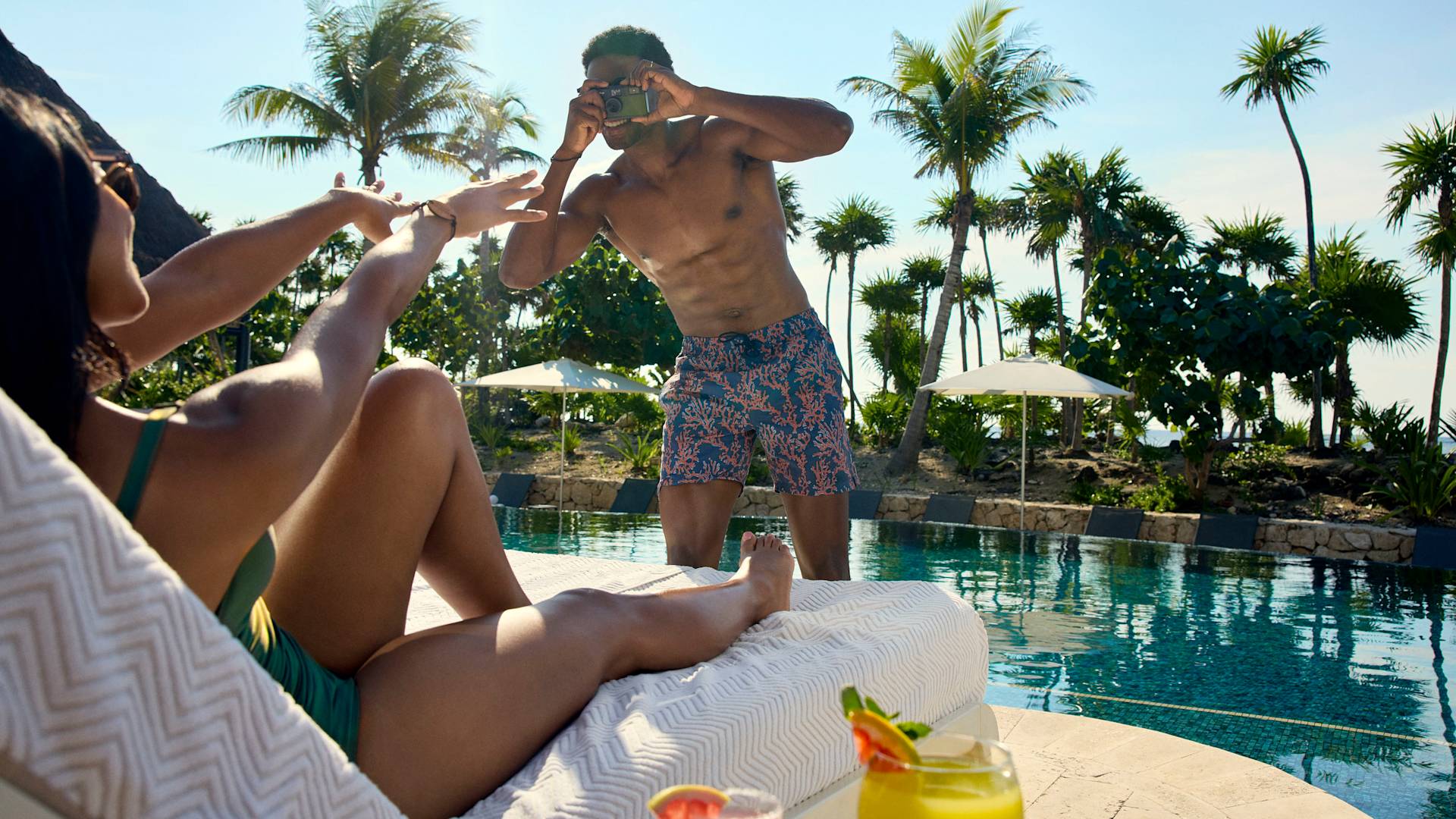 رجل يلتقط صورًا لشريكه في حمام السباحة