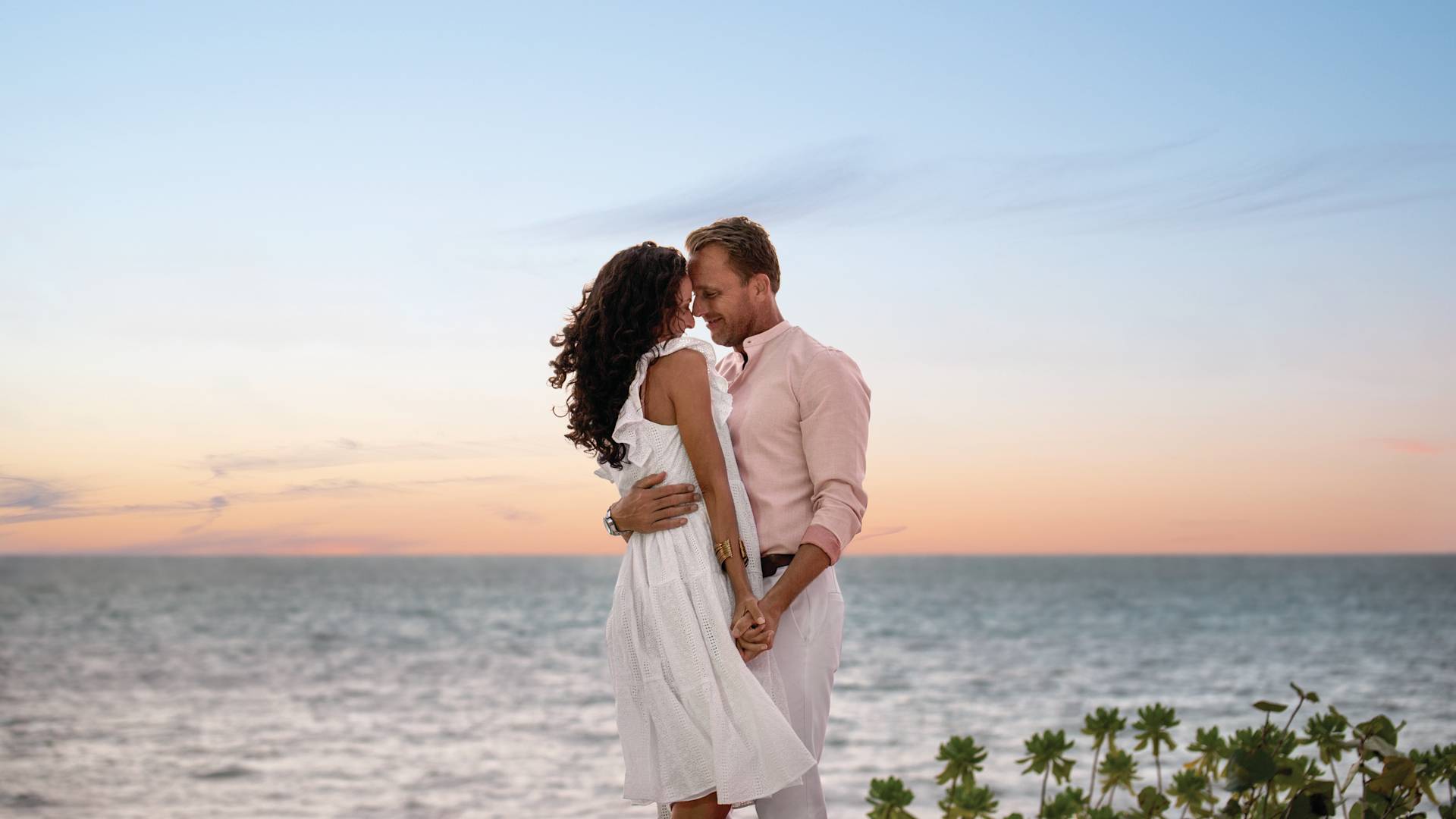 Couple embraces in front of the ocean