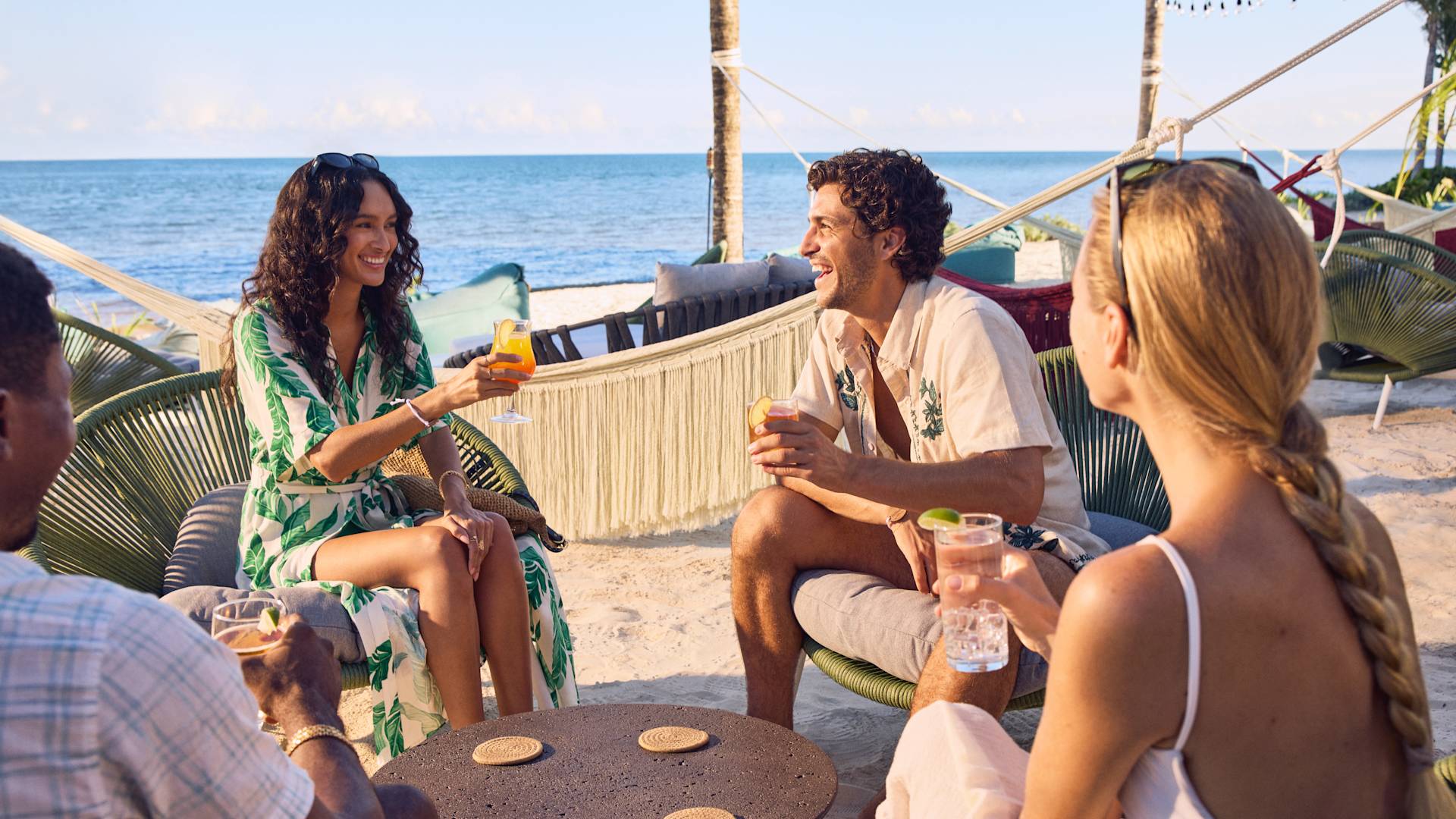 Two men and two women enjoying drinks at the beach club