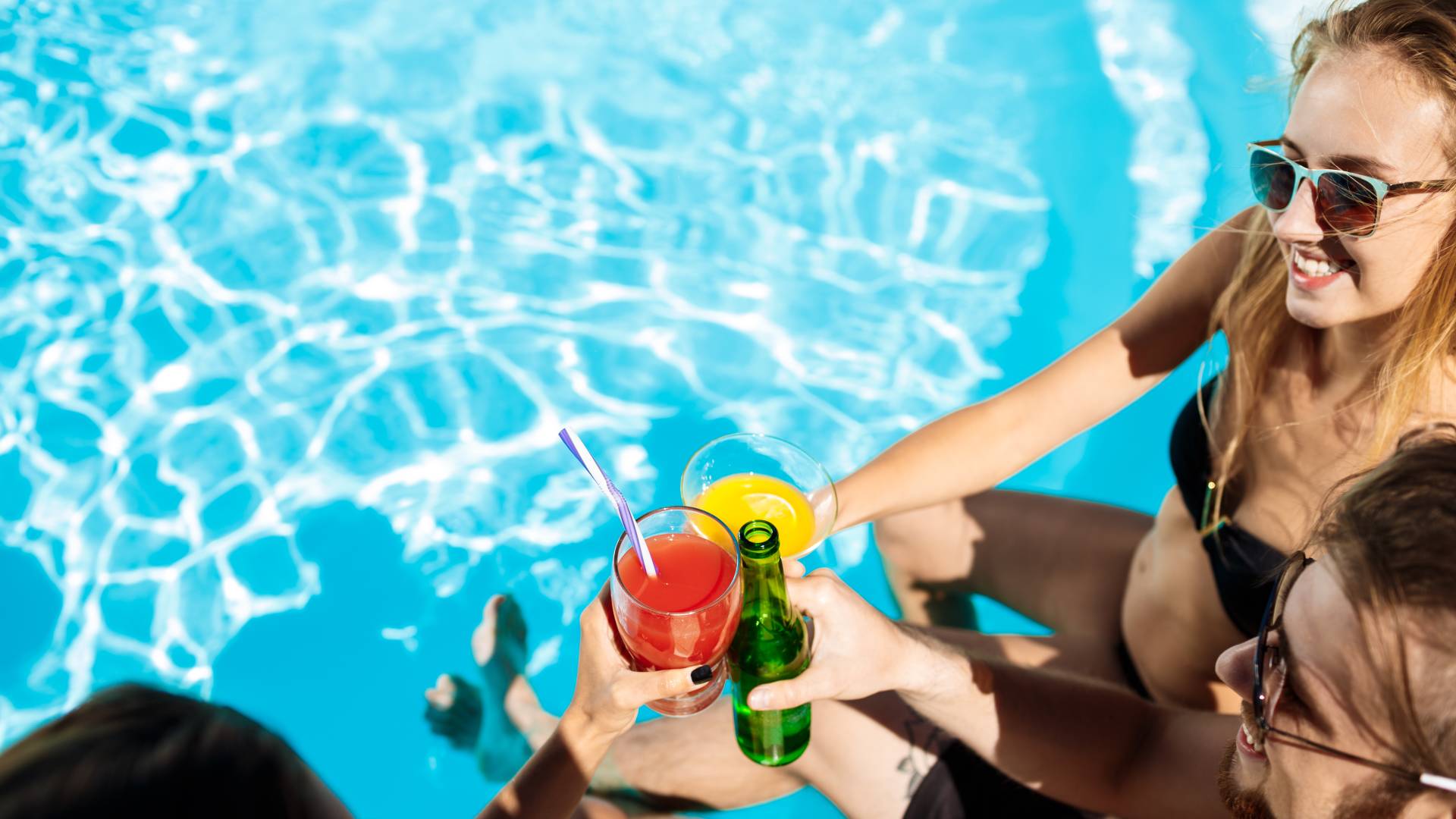 Friends hanging out with drinks in a pool
