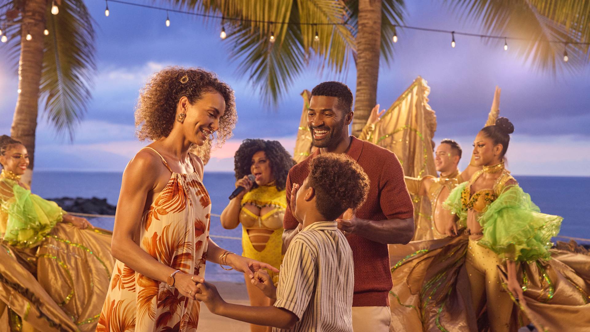 Mère, père et fils profitant de divertissements en soirée avec un groupe et des danseurs
