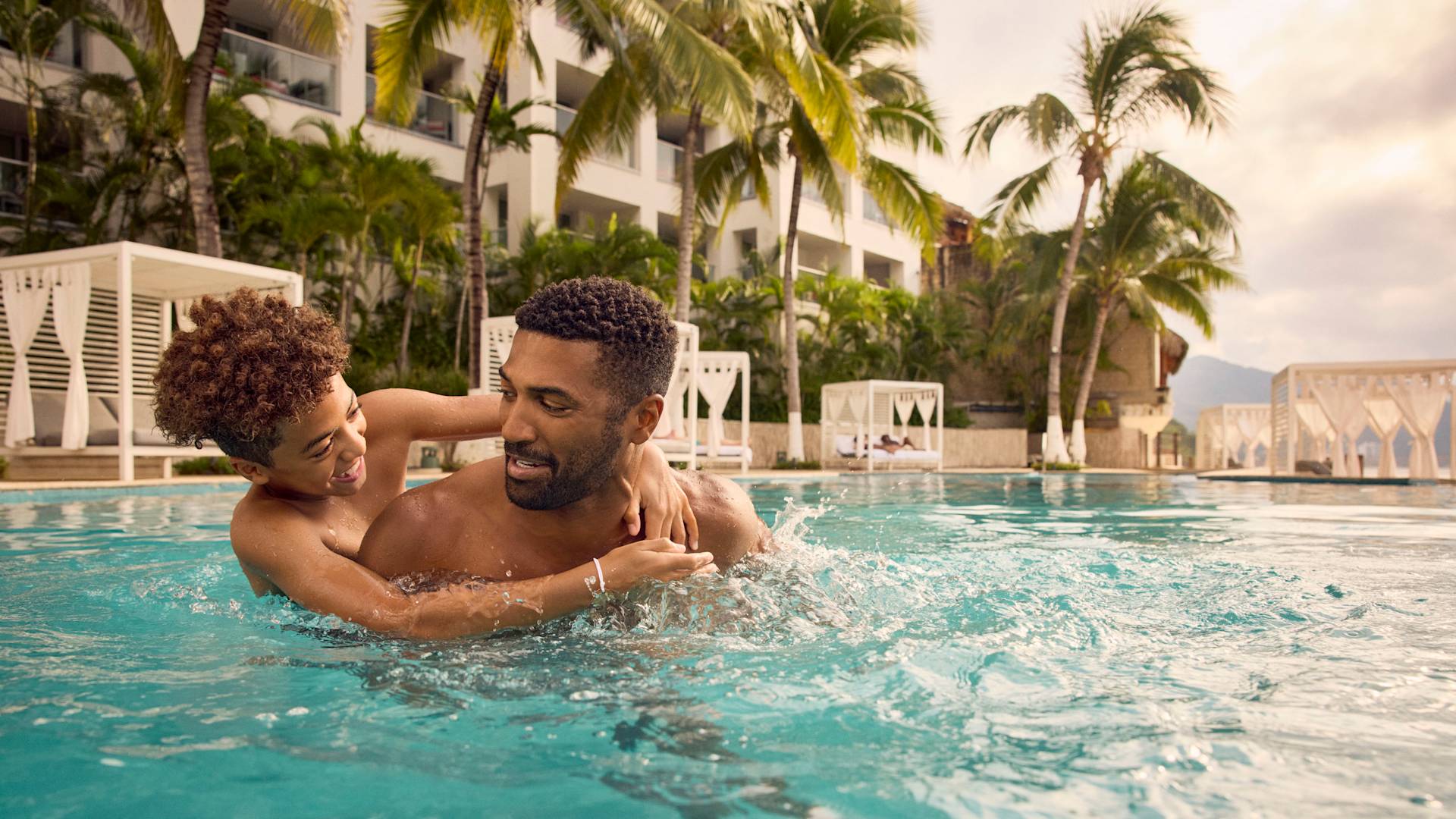 Father and sun splashing about in the hotel pool