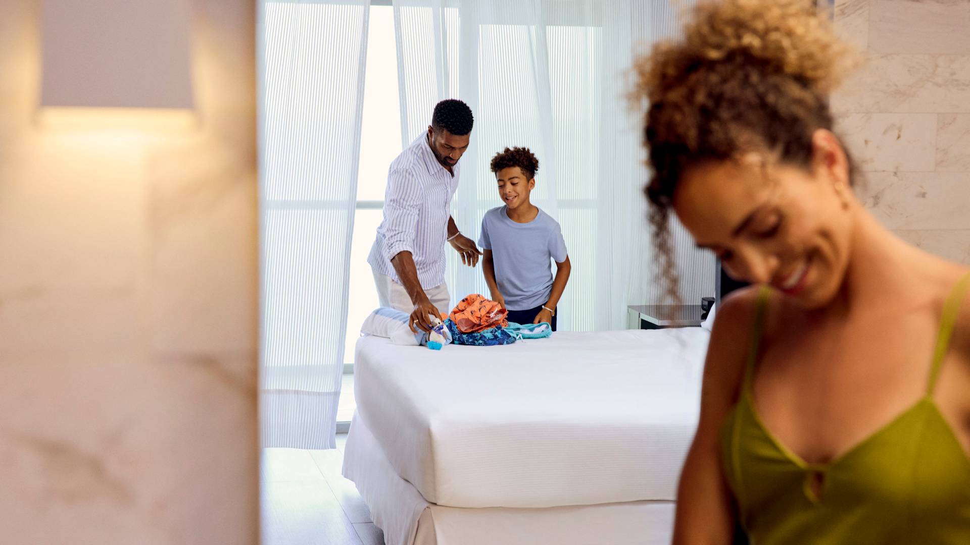 Madre, padre e figlio che disimballano le loro valigie nella suite