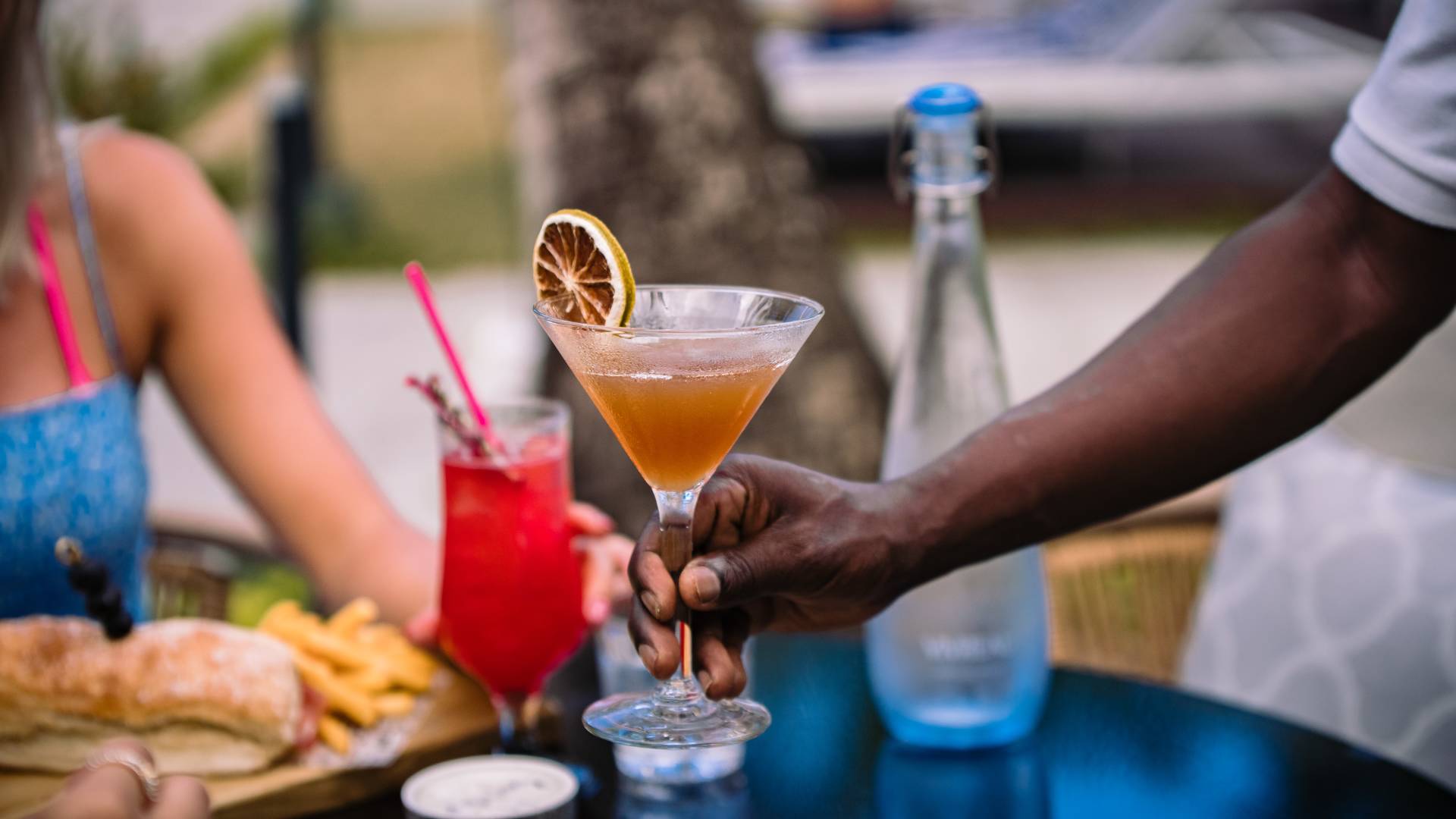 Staff serving cocktail to table