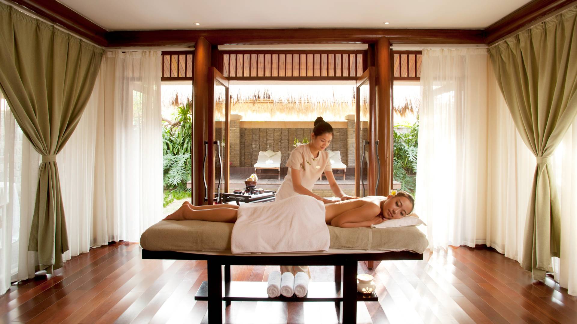 Spa Treatment Room with Woman Recieving Massage by Female Massage Therapist