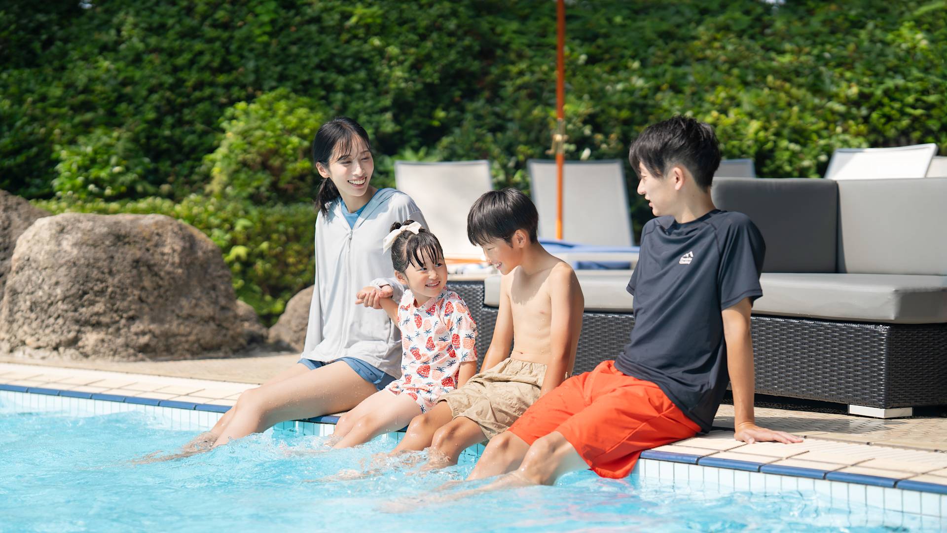 ครอบครัวนั่งอยู่ริมสระ