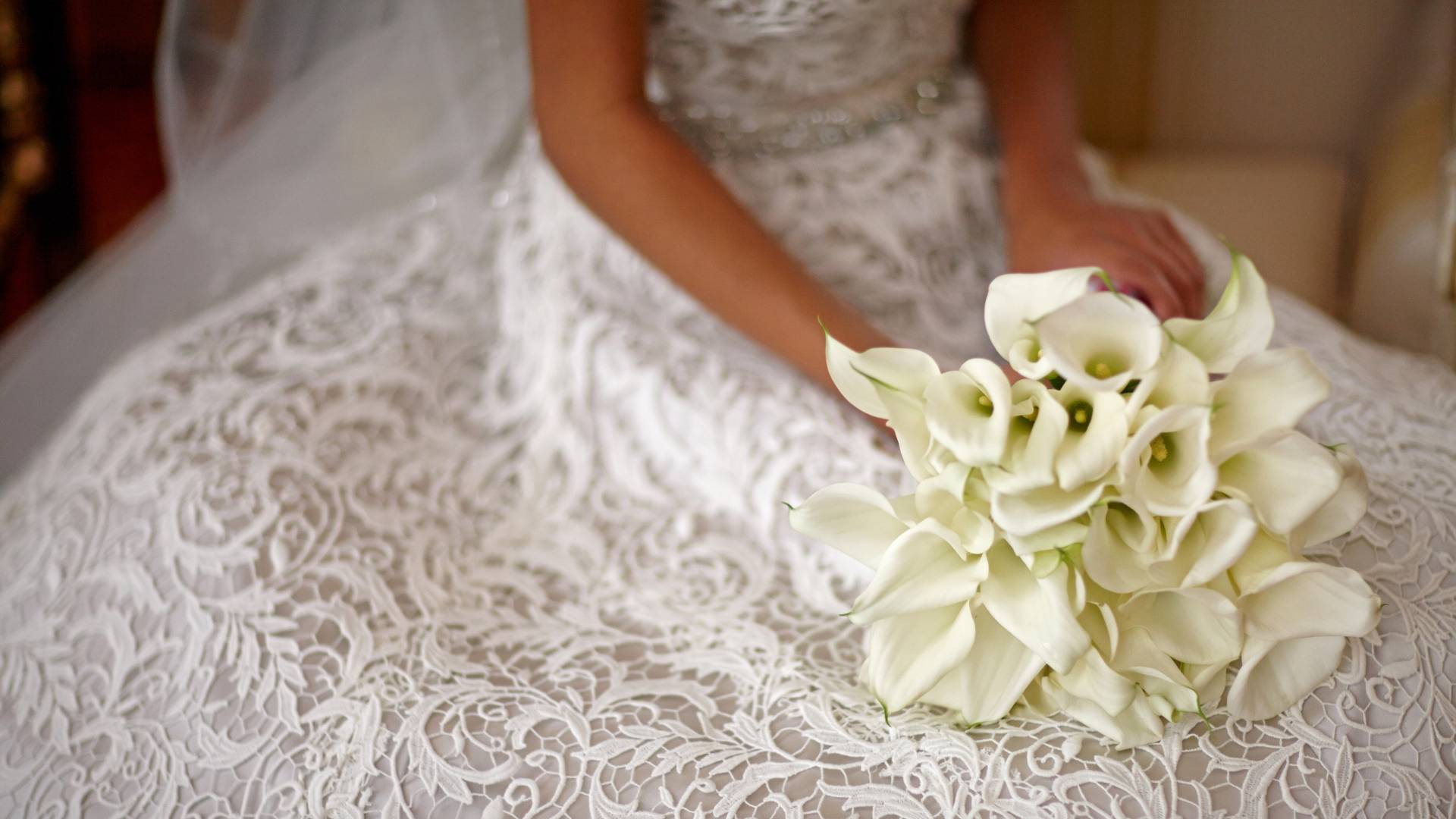 Closeup of bride holding a bouquet of lillies