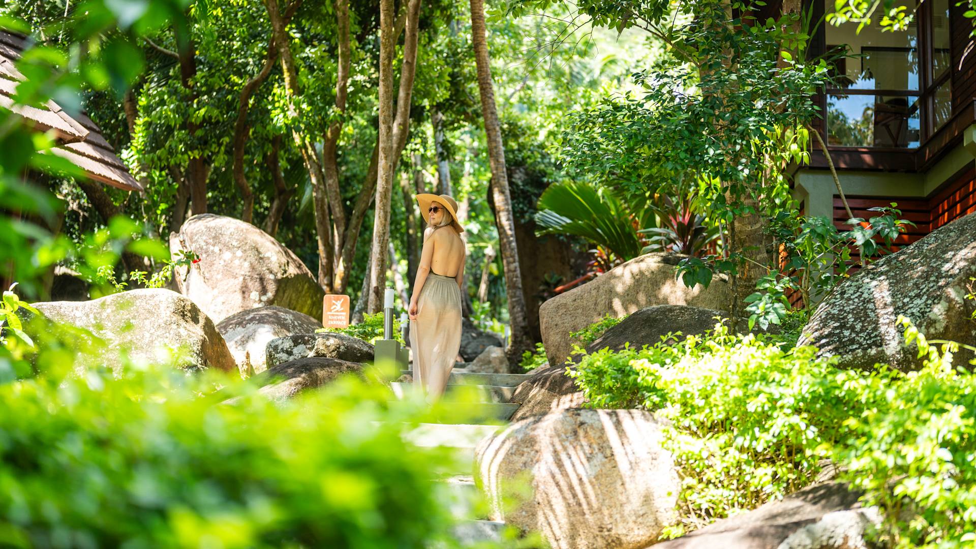 a Woman Walking on an Area with Trees and Rocks