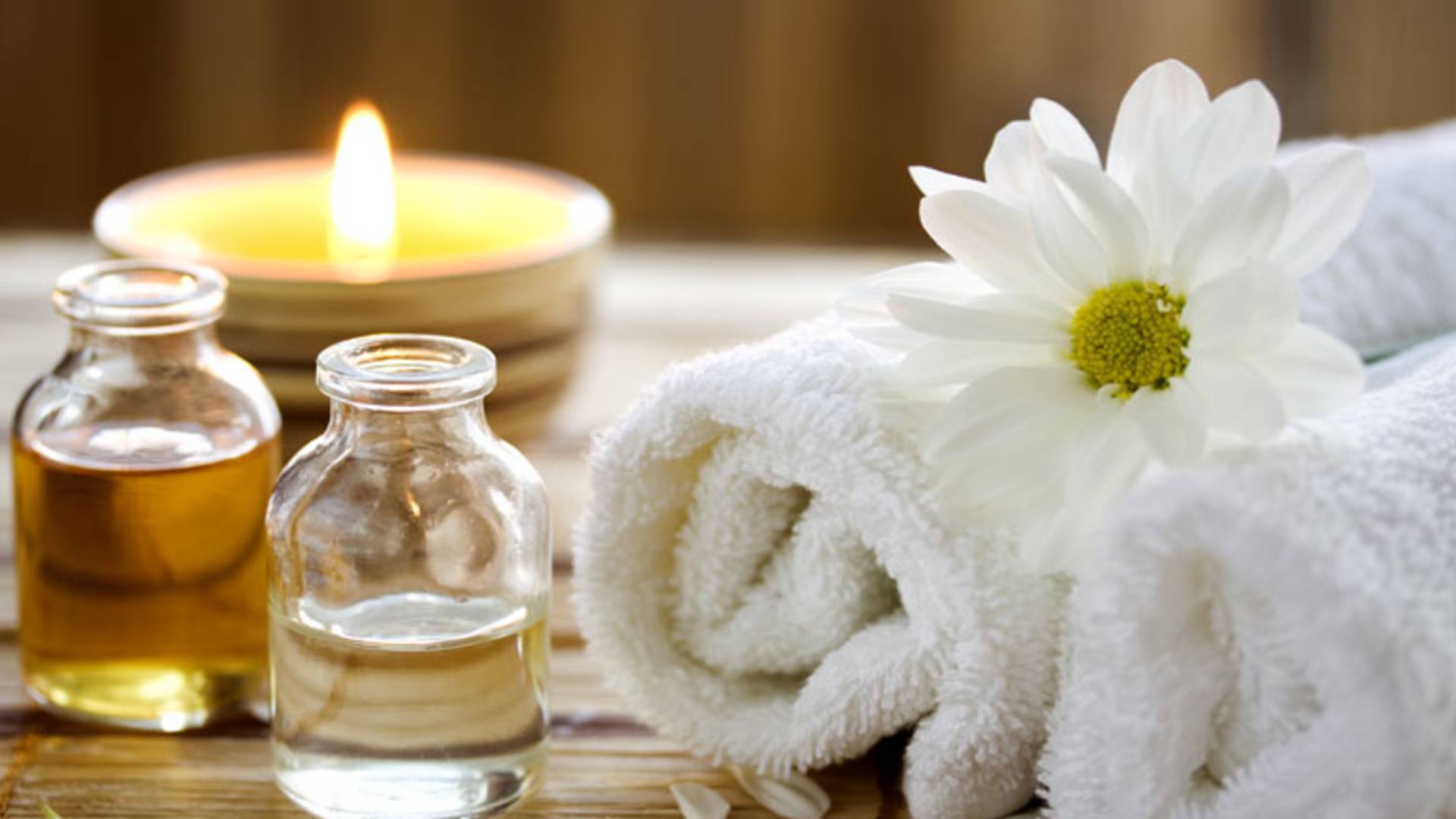 Rolled towels and jars of essential oils in spa