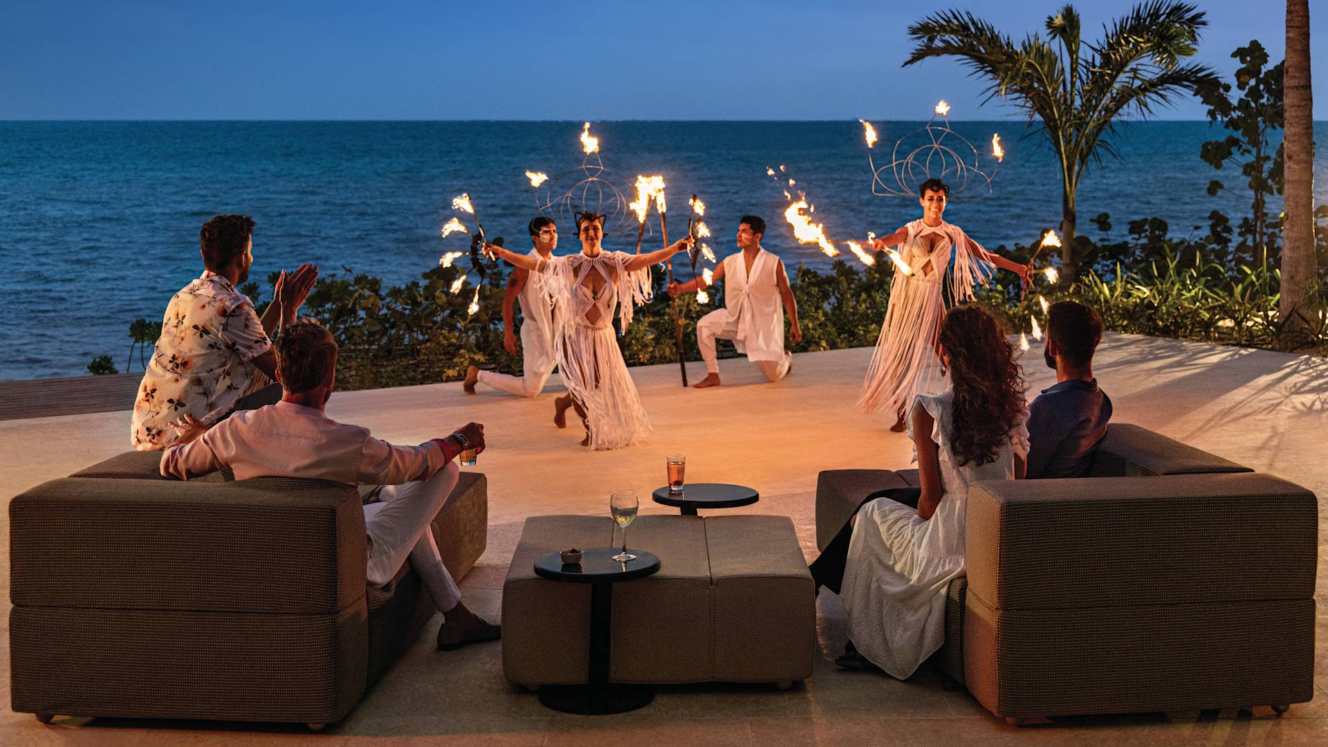 Group of people enjoying fire show outside by the beach