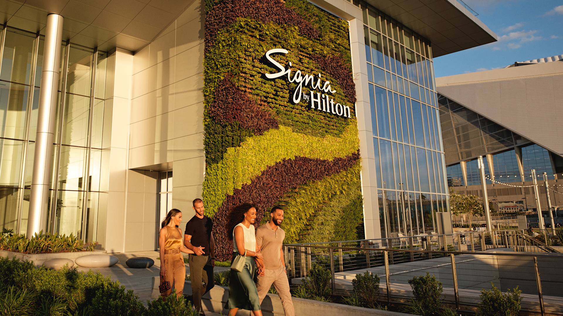Group of friends leaving hotel, walking past hotel signage
