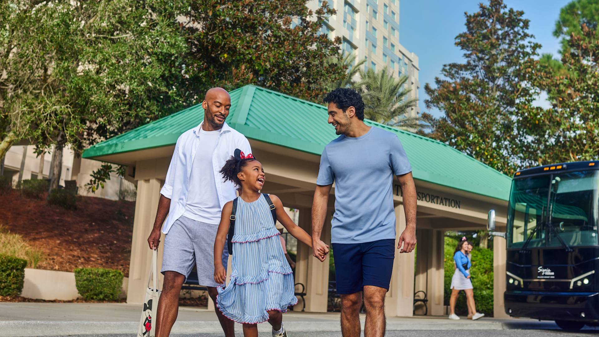Deux hommes et une jeune fille marchant main dans la main