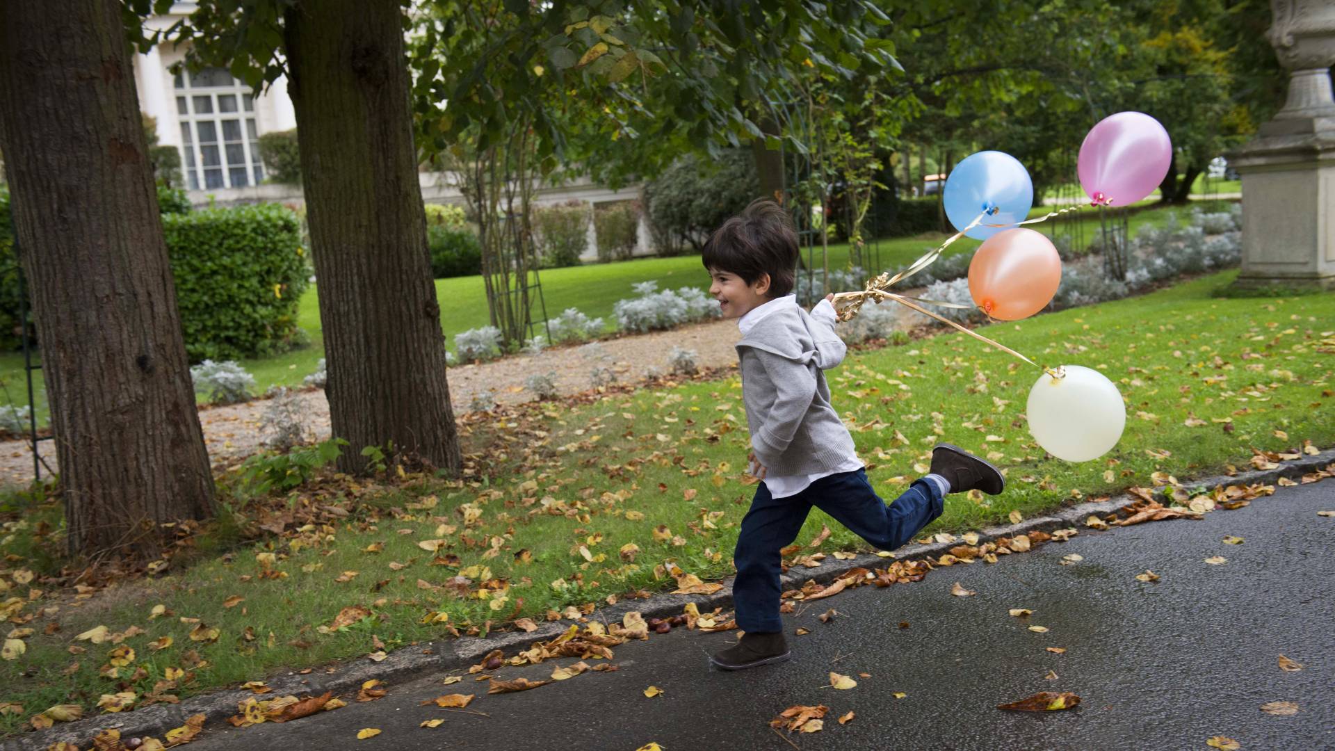 Junge beim Laufen mit Ballons