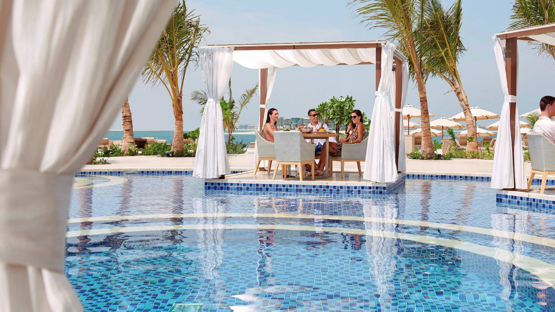 People dining in pool cabanas