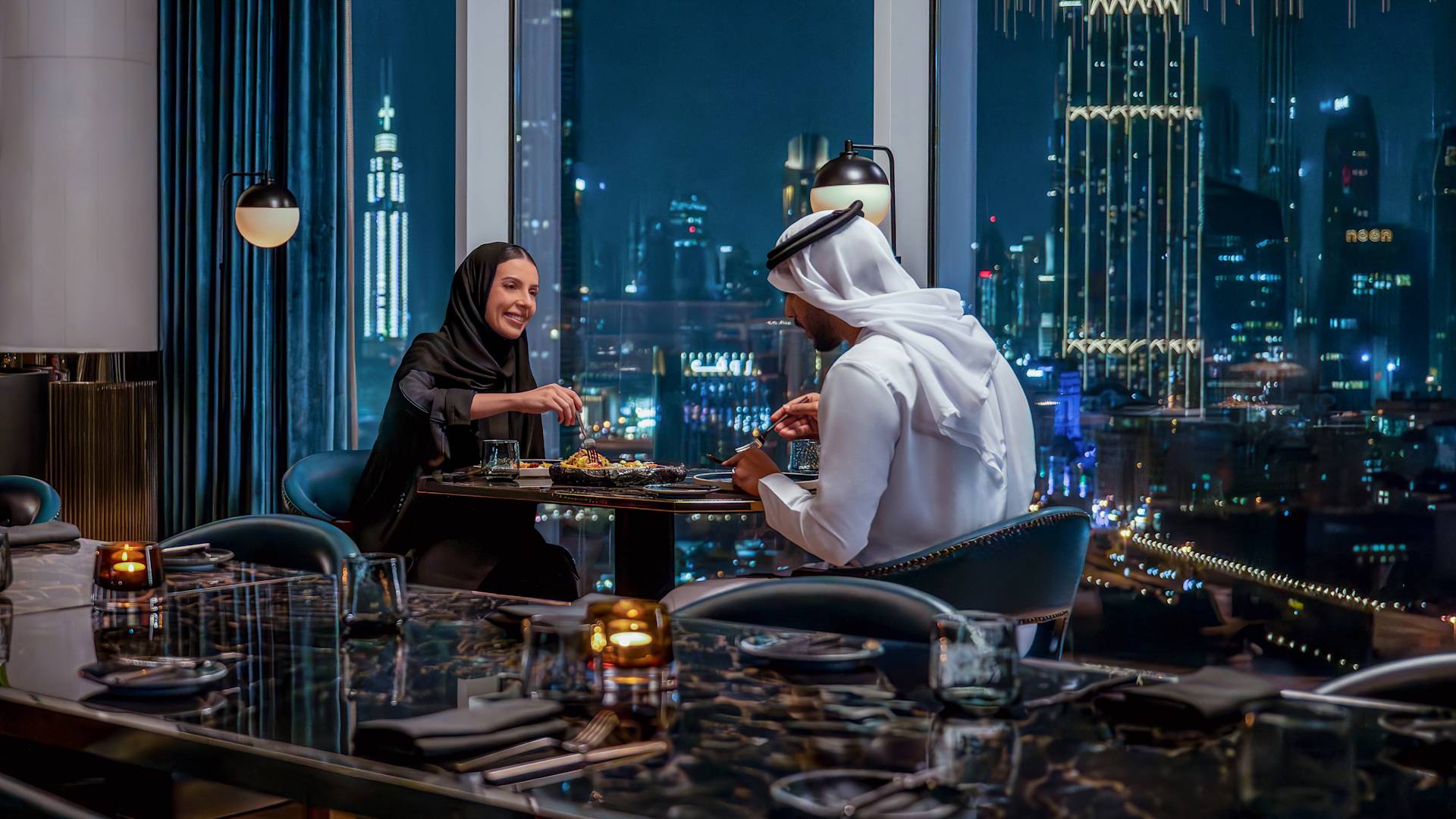 Man and woman relaxing in restaurant seating area with city view