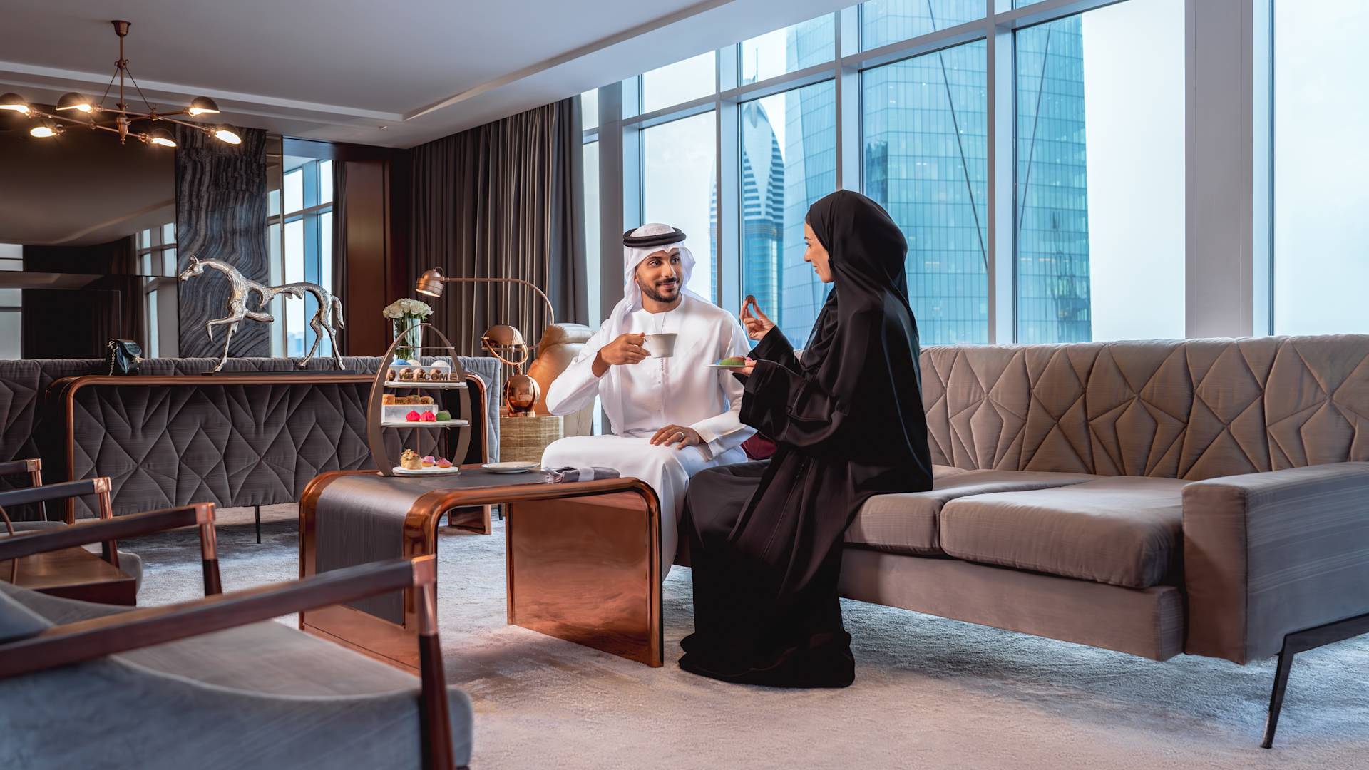 Man and woman relaxing in lounge area with afternoon tea