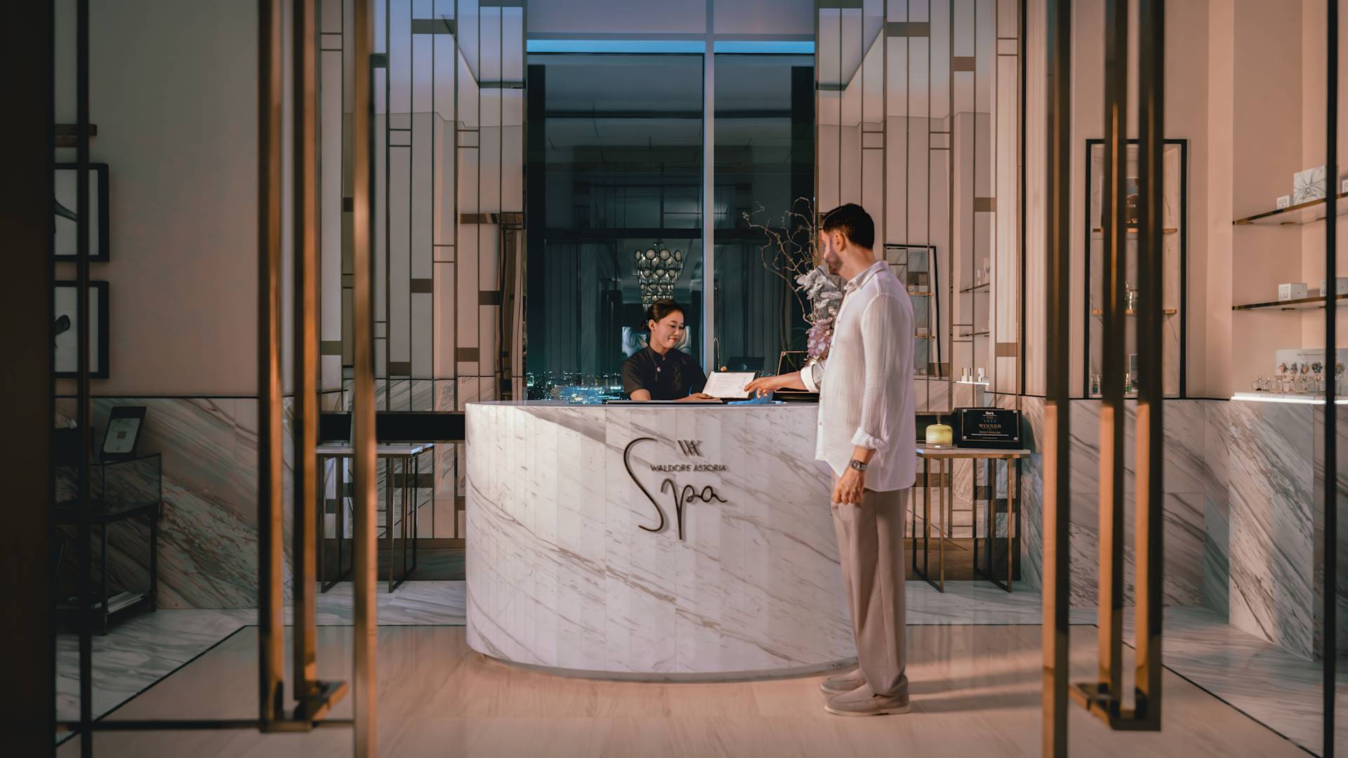 Spa reception with man handing paper across to staff member