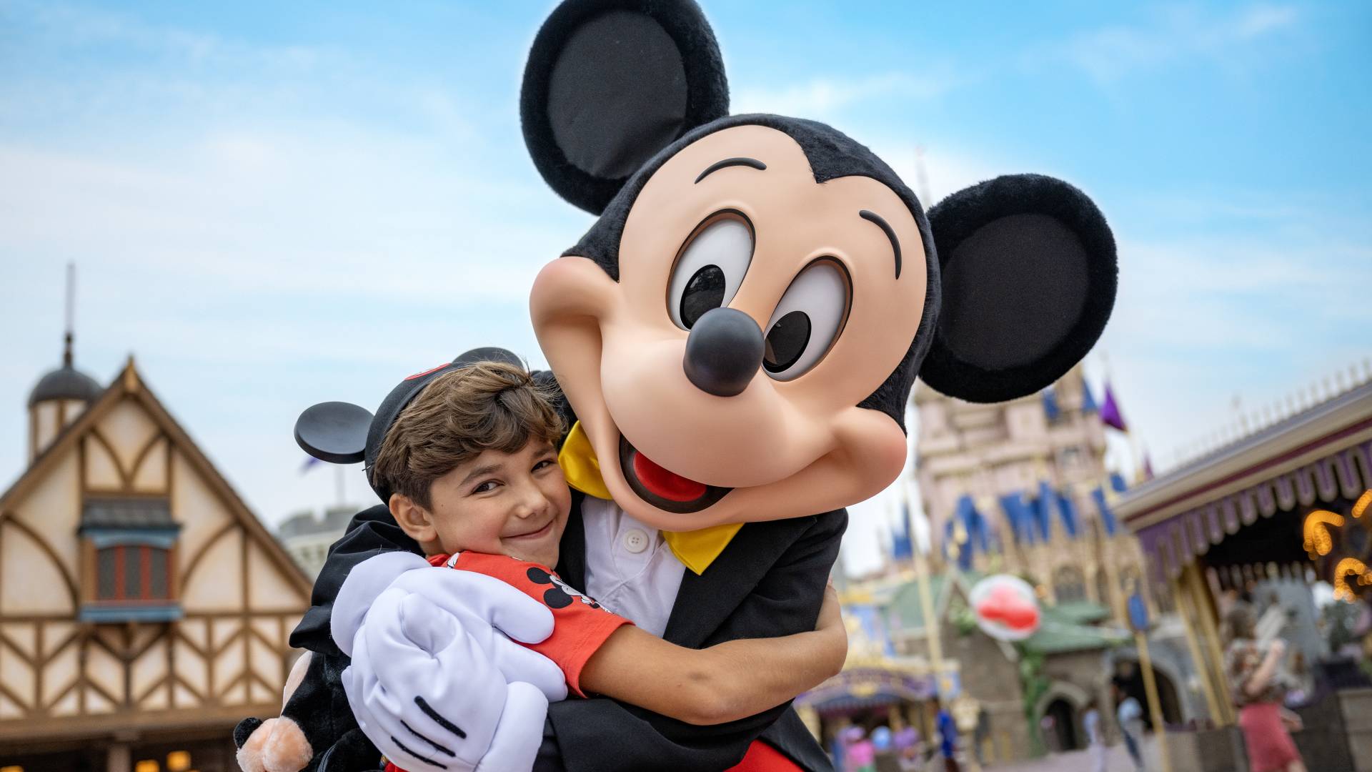 a little boy hugging Mickey Mouse