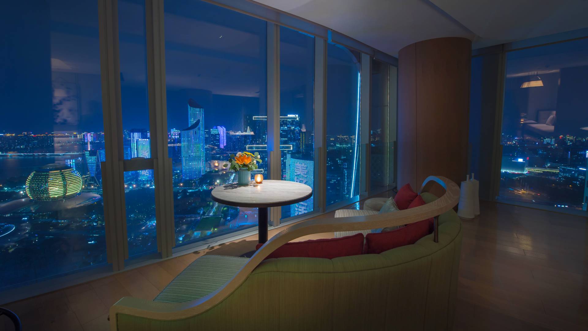 Executive Lounge plush couch facing floor-to-ceiling windows at night