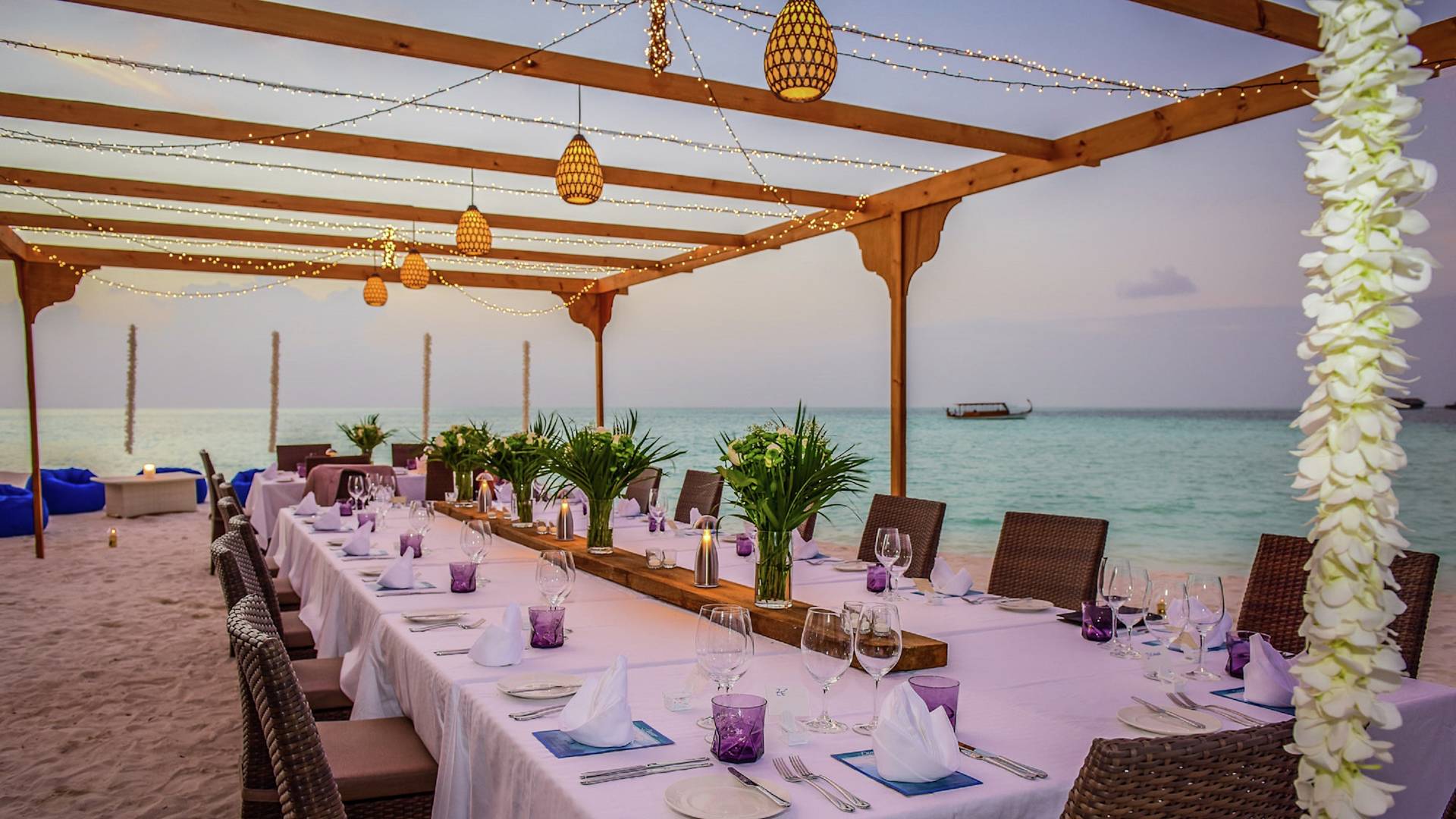 Una mesa formal para eventos en una playa de arena