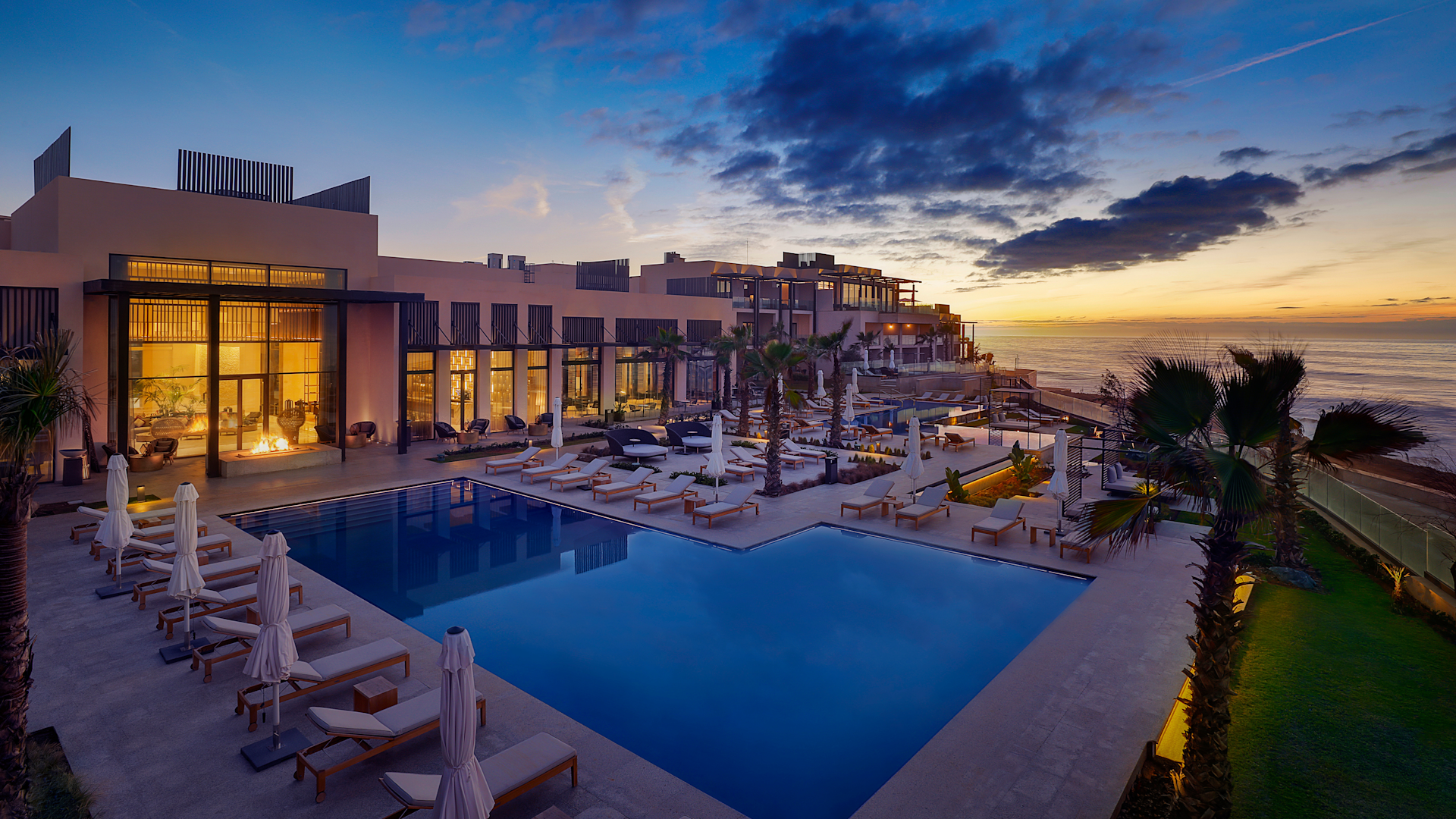 Esterno dell'hotel con ampia piscina al tramonto